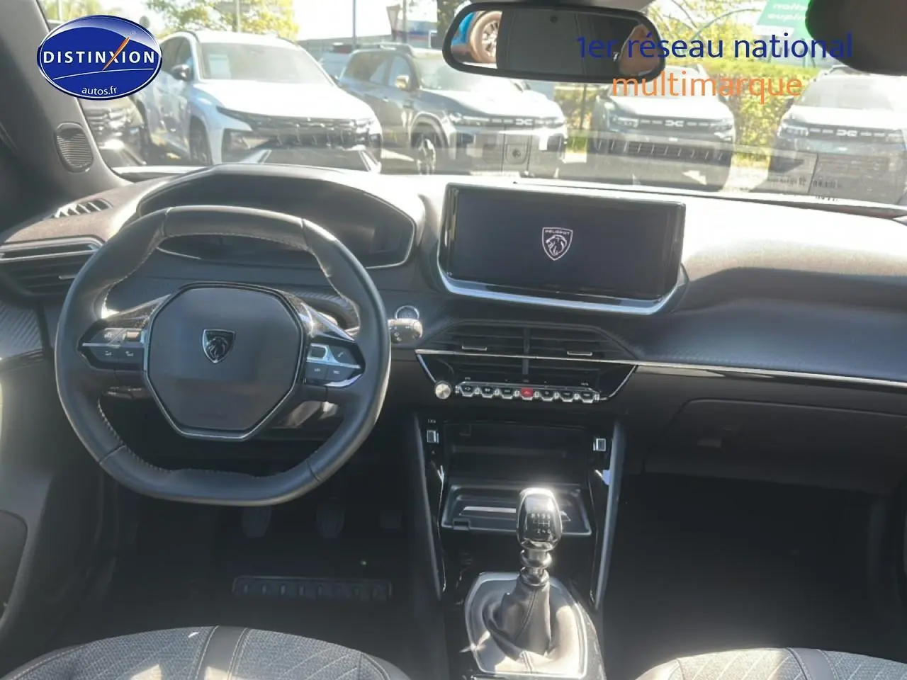 Vue intérieure du tableau de bord et volant de la Peugeot 2008 gris artense avec boîte manuelle et écran tactile central.