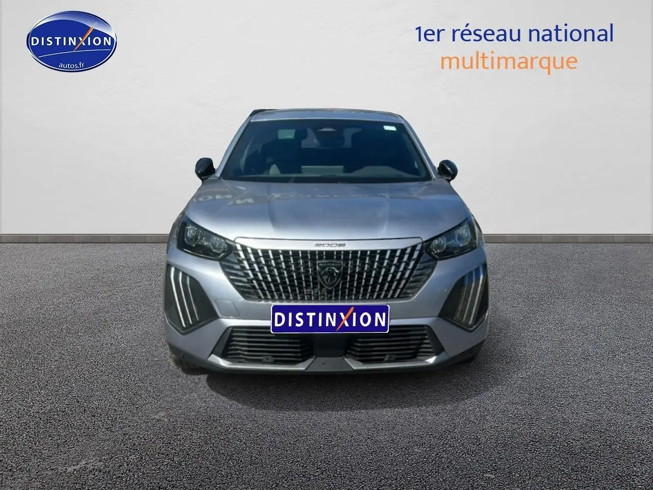 Vue avant d’un Peugeot 2008 gris artense avec calandre distinctive et feux LED verticaux allumés.