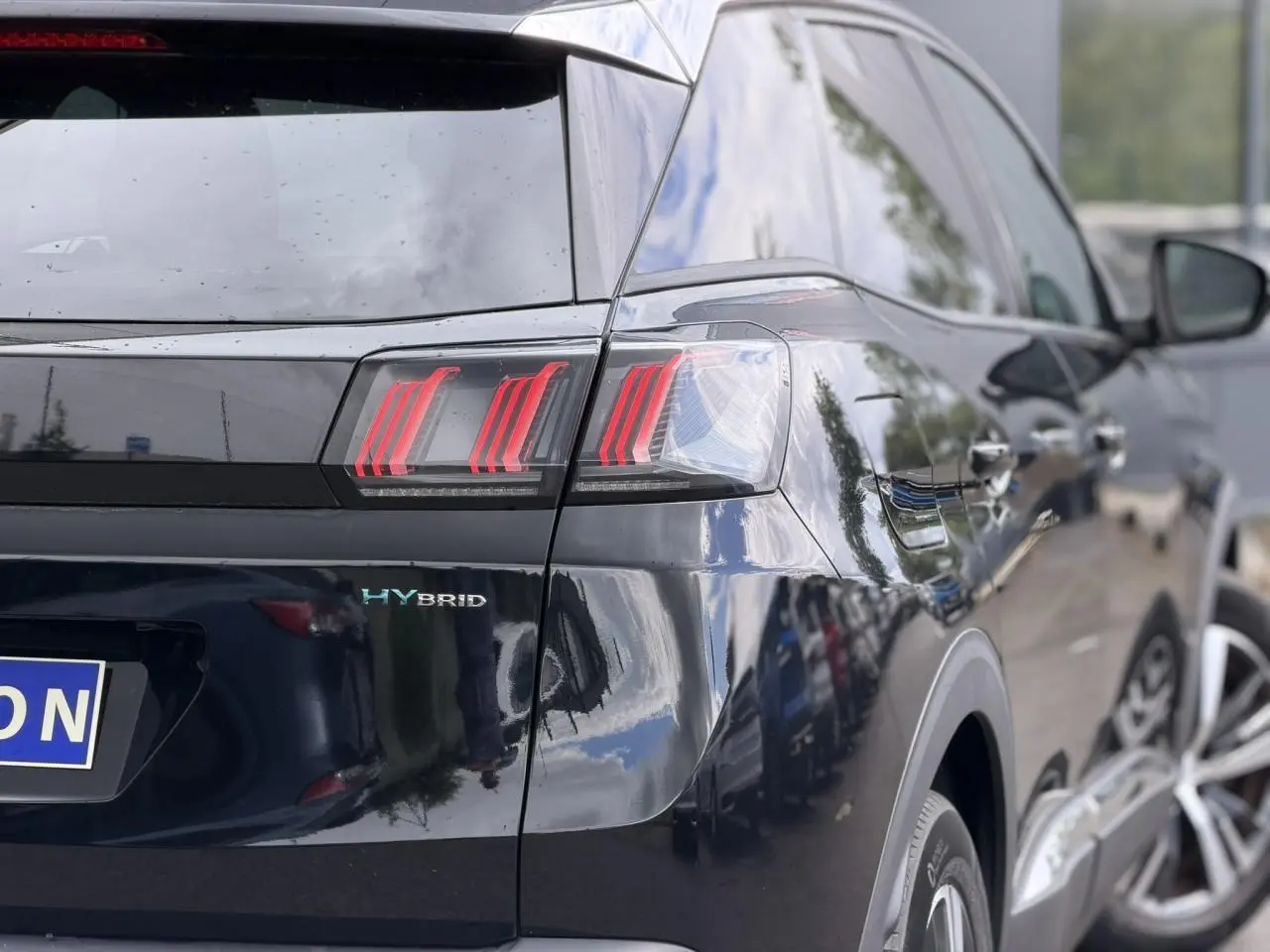 Vue arrière droite du Peugeot 3008 noir Perla avec badge HYBRID et feux arrière LED distinctifs.