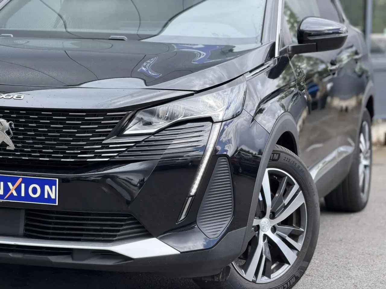 Vue 3/4 avant droit du Peugeot 3008 noir Perla avec jantes alliage bi-ton et signature lumineuse LED distinctive.