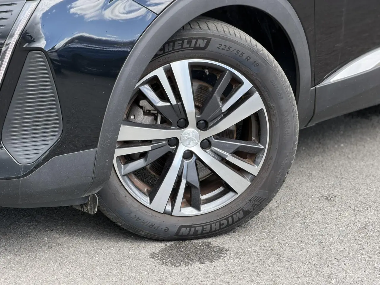 Gros plan sur la roue avant gauche du Peugeot 3008 noir Perla avec jante alliage bi-ton 18 pouces Detroit.