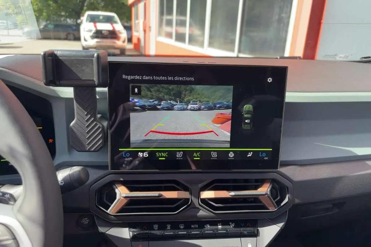 Vue intérieure du tableau de bord du Dacia Bigster Hybrid-G 150 4x4, écran central affichant la caméra de recul.
