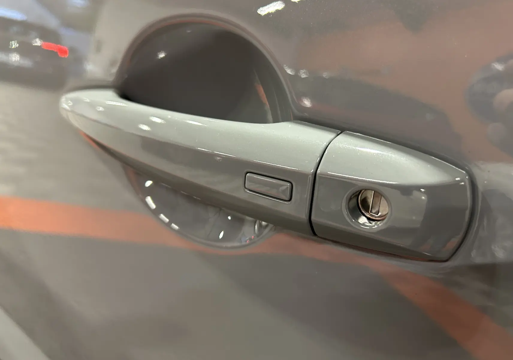 Poignée de porte gris céramique métal du Nissan Qashqai 2025, version N-Design avec serrure visible en gros plan.