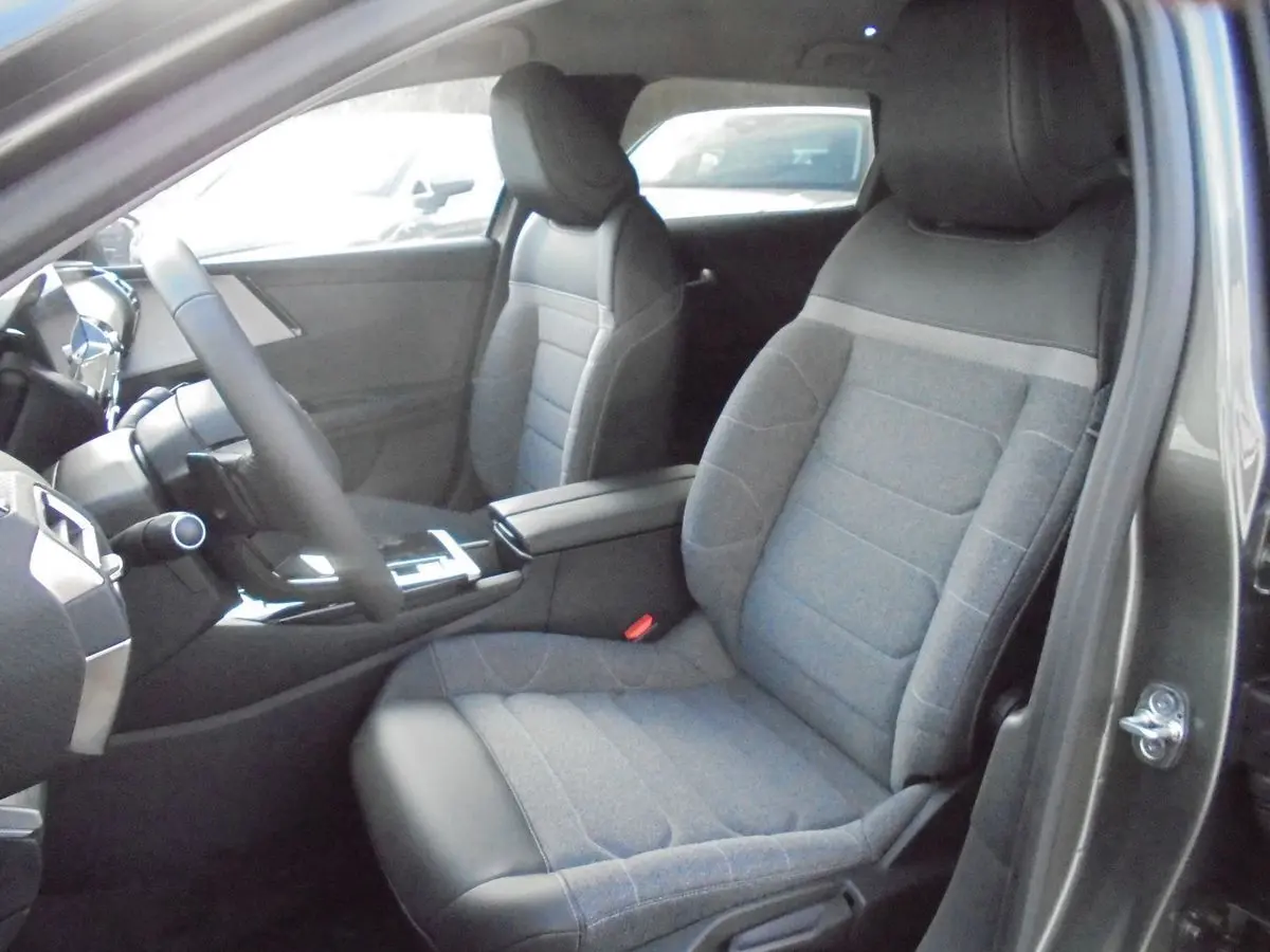 Vue intérieure côté conducteur du Citroën C5 X 2022 gris platinum, montrant les sièges tissu et cuir et la console centrale.