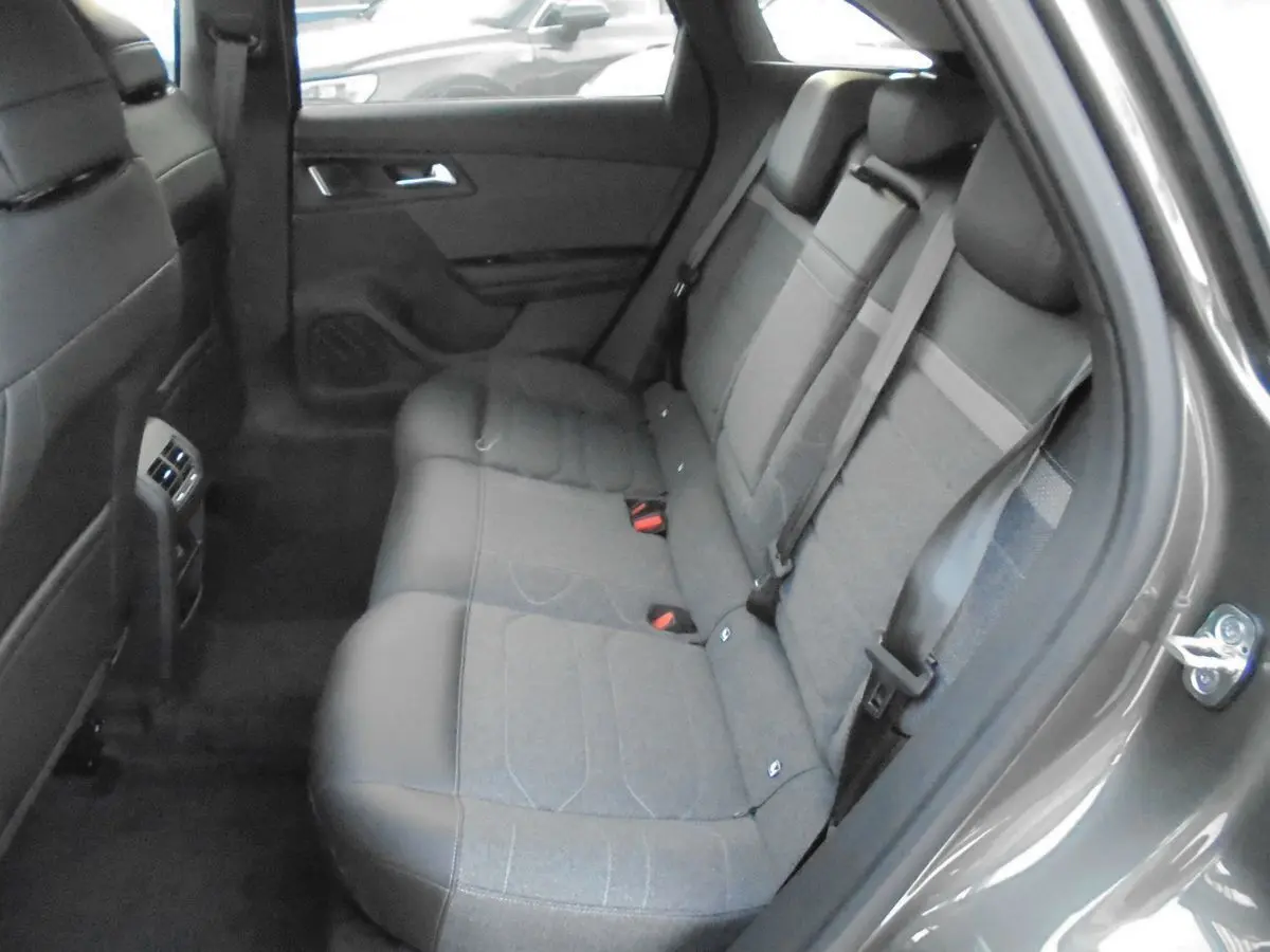 Vue intérieure côté droit des sièges arrière en tissu gris du Citroën C5 X gris platinum, avec ceinture de sécurité visible.