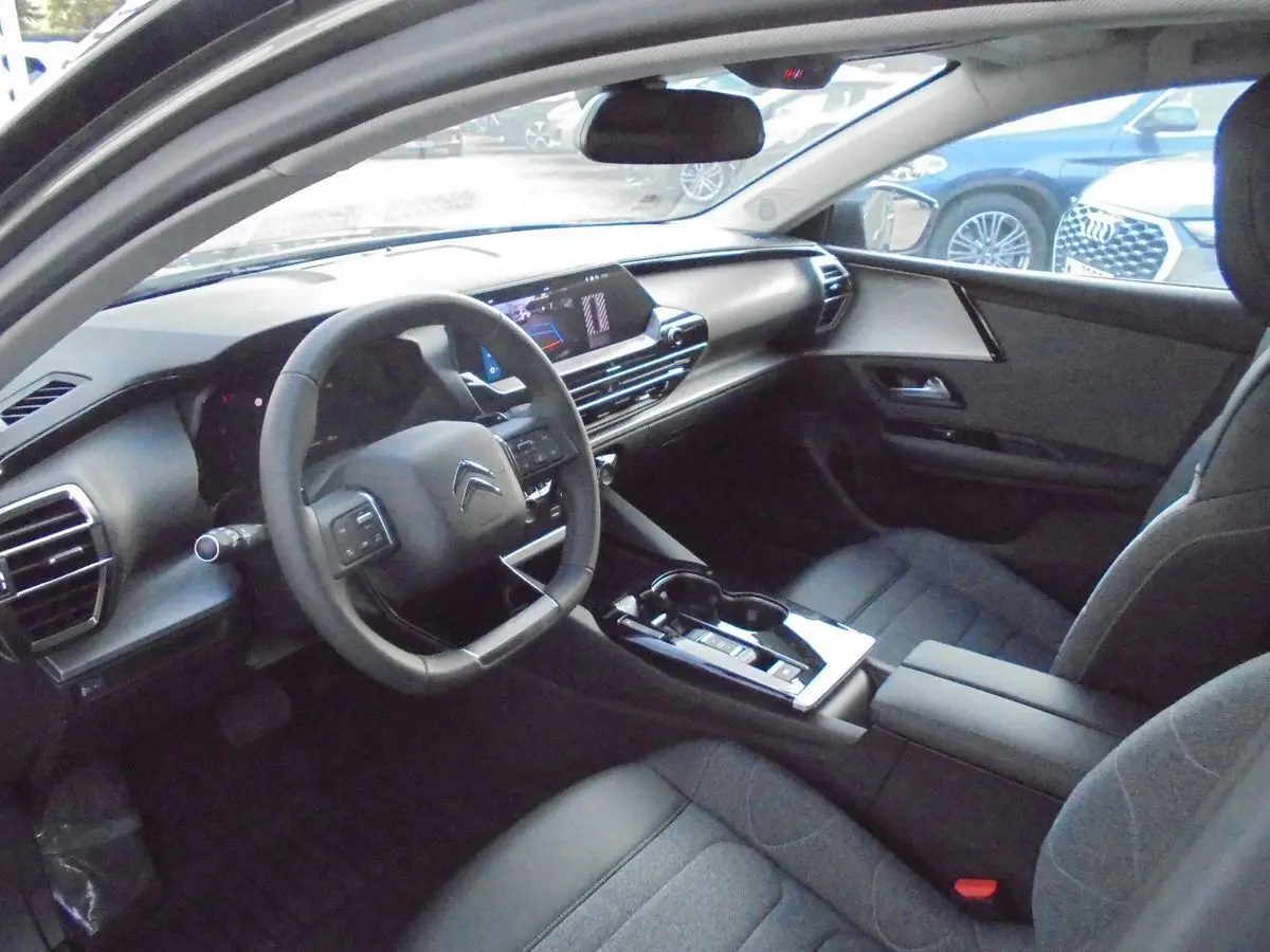 Intérieur du Citroën C5 X 2022 en gris platinum, vue côté conducteur montrant le tableau de bord et la console centrale moderne.
