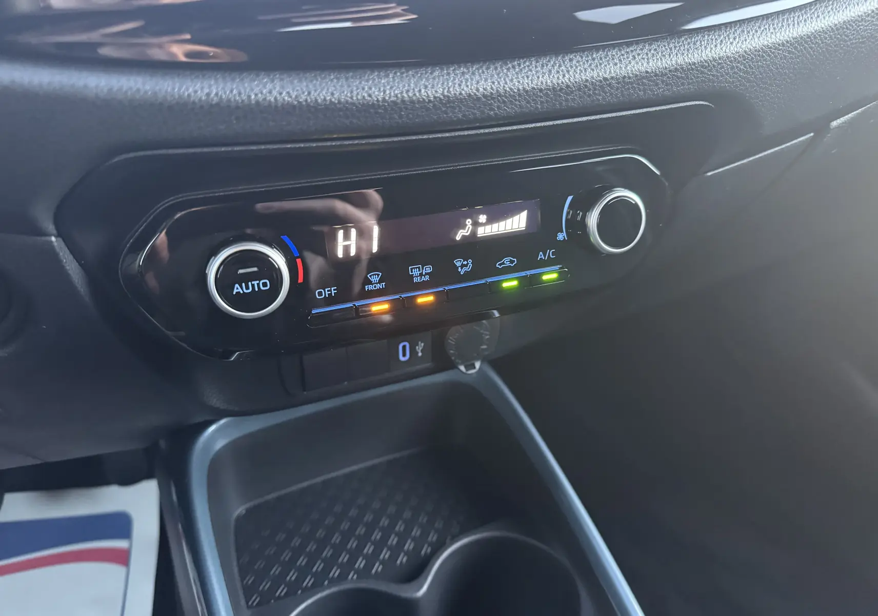 Gros plan sur la console centrale noire du Toyota Aygo X 2025, affichant le contrôle automatique de la climatisation.