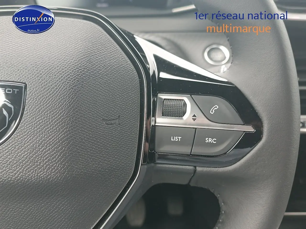 Gros plan sur le volant multifonction noir du Peugeot 2008 1.2 100 Allure avec commandes audio intégrées.