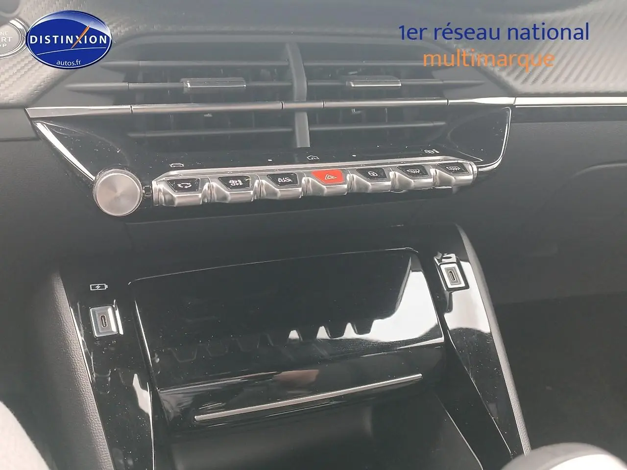 Vue rapprochée de la console centrale noire brillante du Peugeot 2008 1.2 100 allure, avec commandes et aérateurs visibles.