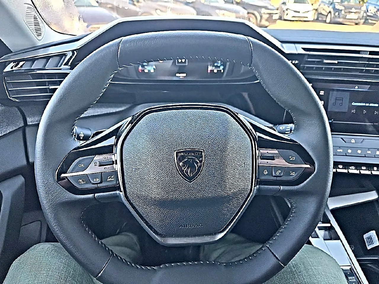 Vue rapprochée du volant multifonction noir de la Peugeot 308 SW 2025 avec tableau de bord et écran tactile visibles.