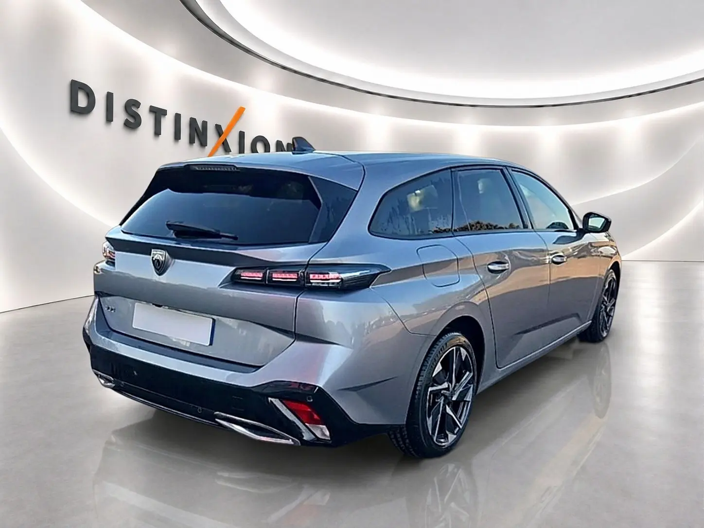 Peugeot 308 SW gris artense vue 3/4 arrière droit, jantes alliage et vitres arrière surteintées.