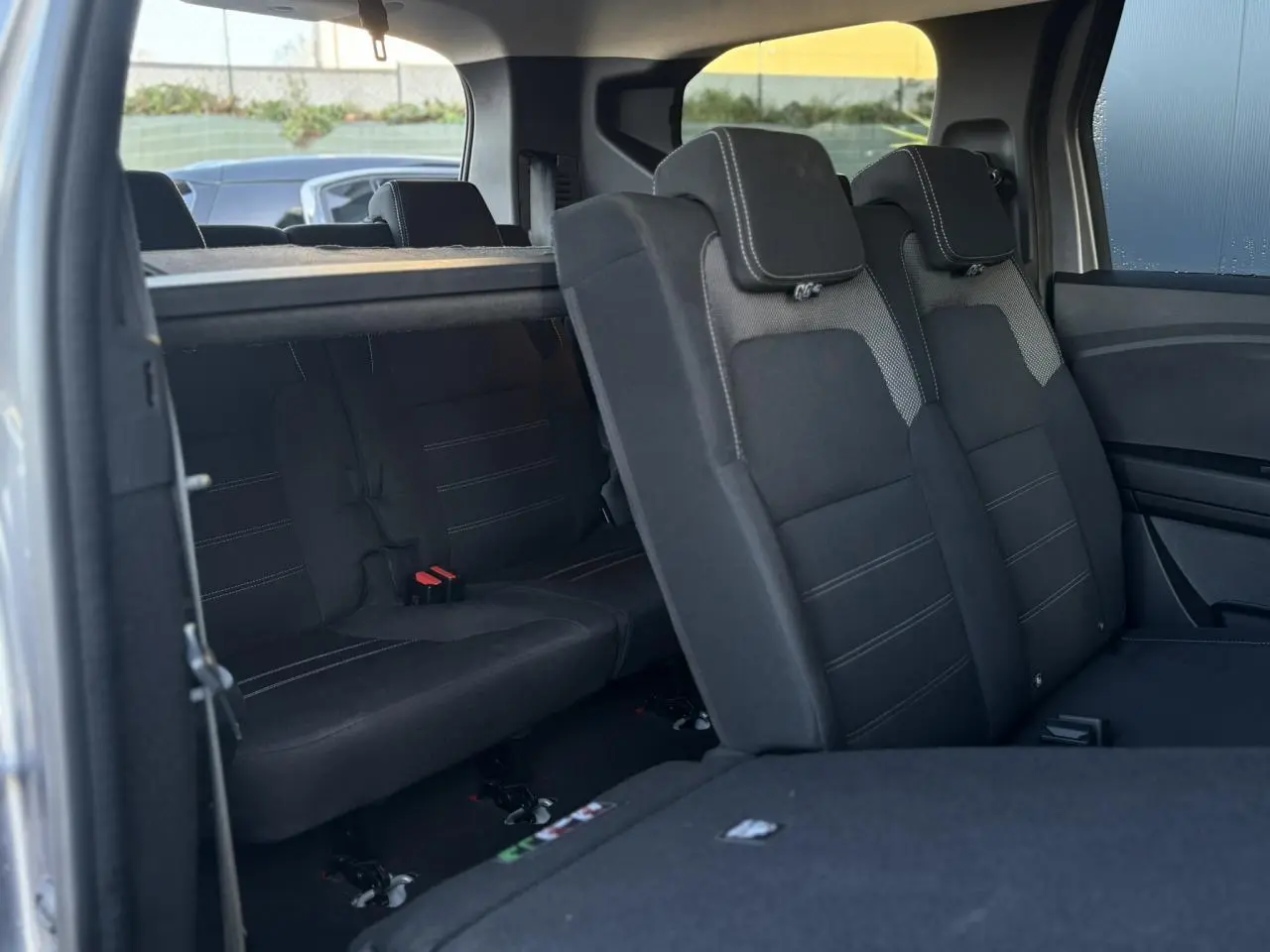 Vue intérieure côté droit du DACIA JOGGER gris Schiste, montrant les sièges arrière rabattables en tissu noir.