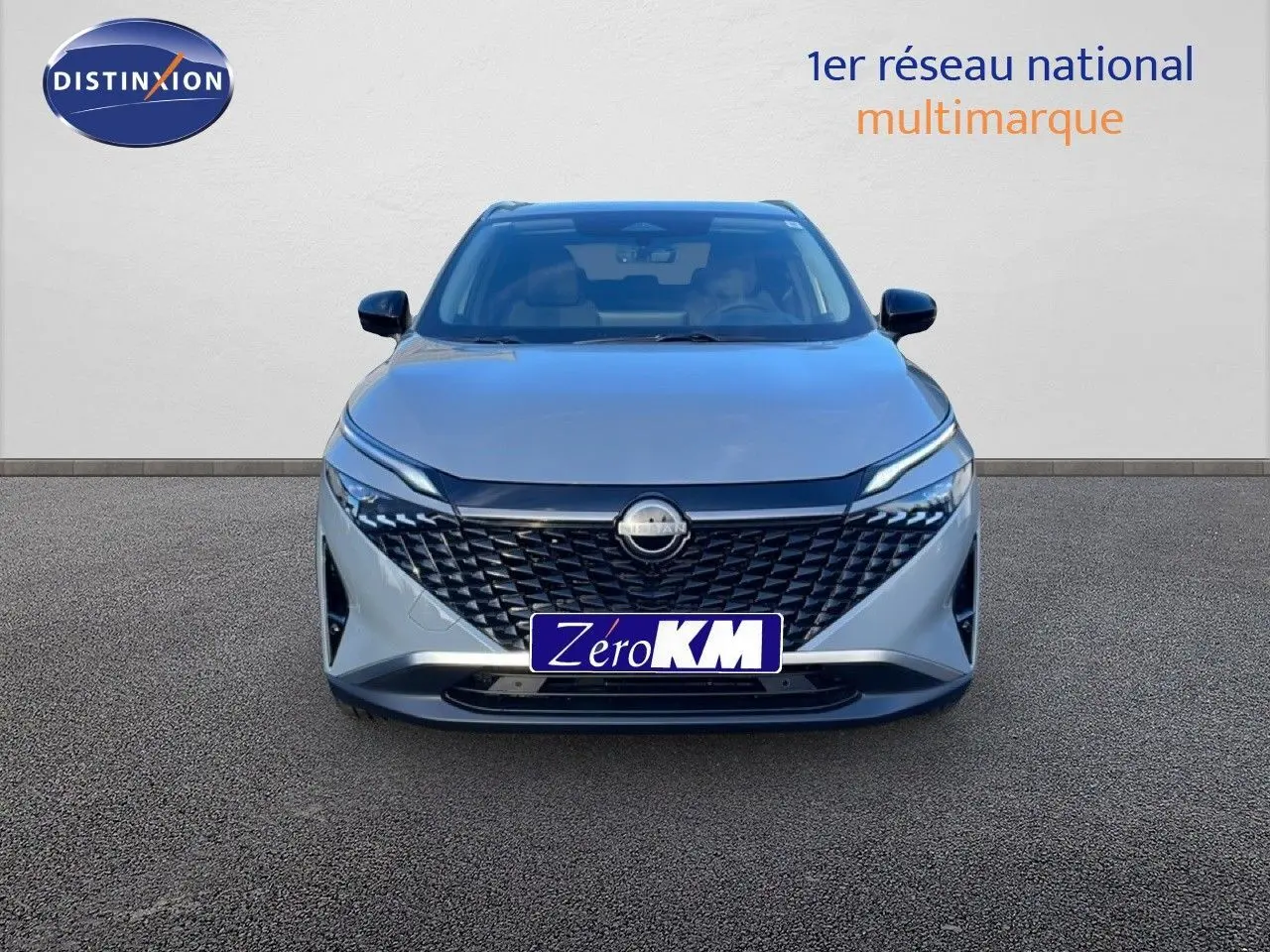 Vue de face du Nissan Qashqai 2025 gris argile métal avec calandre noire et phares LED fins.