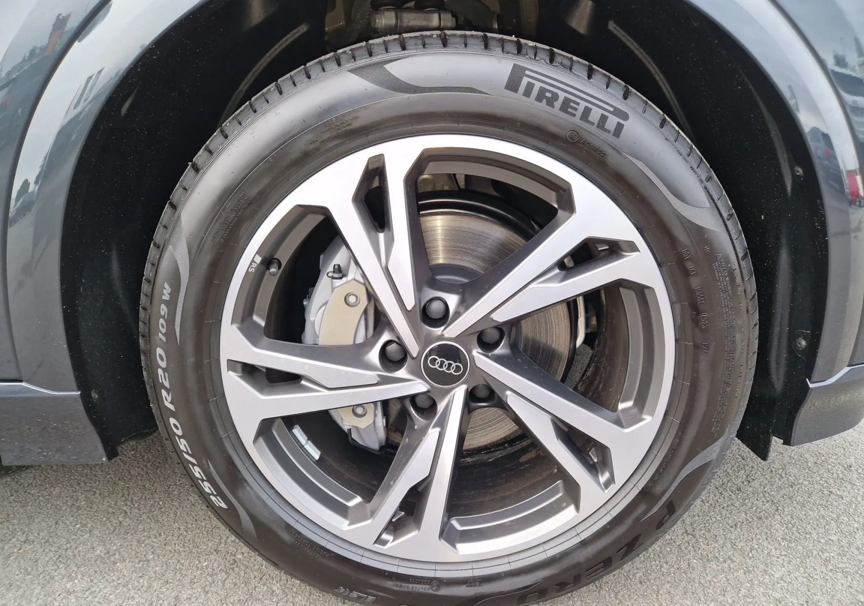 Gros plan sur la jante alliage grise et le pneu Pirelli du côté avant droit de l'Audi Q6 e-tron Performance S-Line gris Manhattan.