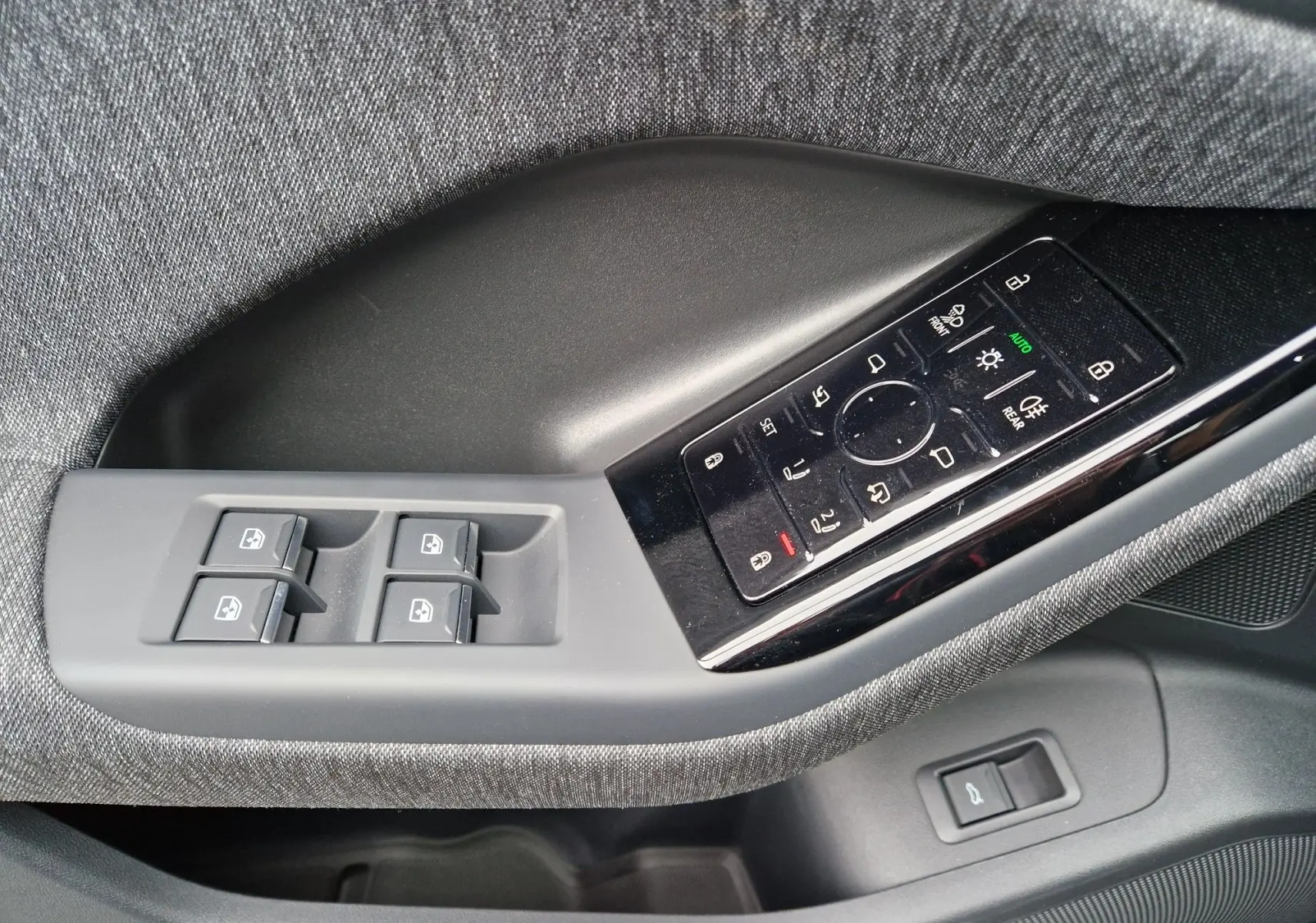 Gros plan sur la commande des vitres et réglages des rétroviseurs côté gauche de l'Audi Q6 e-tron Performance S-Line gris Manhattan.