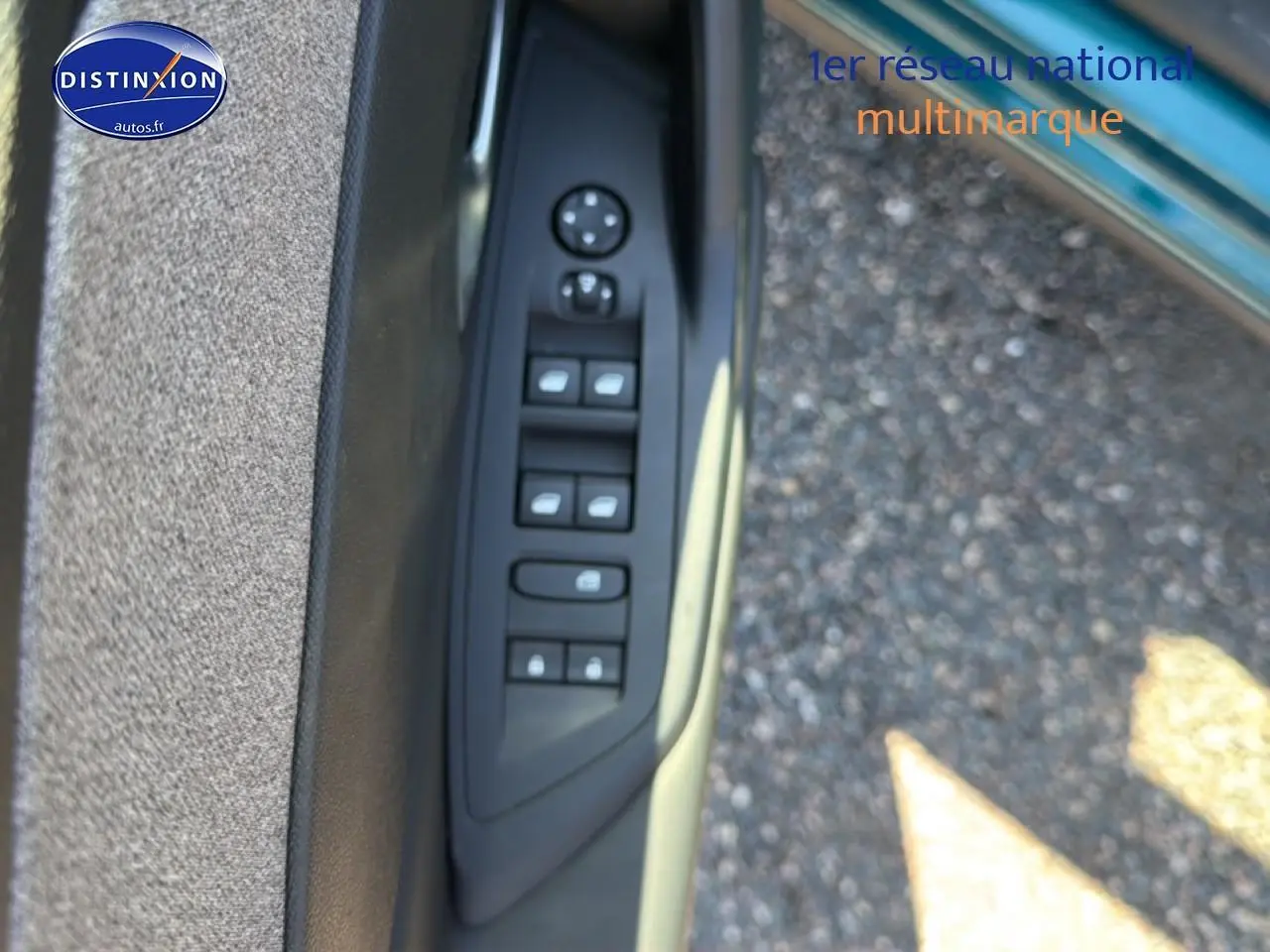 Panneau de porte côté conducteur de Peugeot 408 Hybrid bleu, avec commandes électriques des vitres et rétroviseurs.