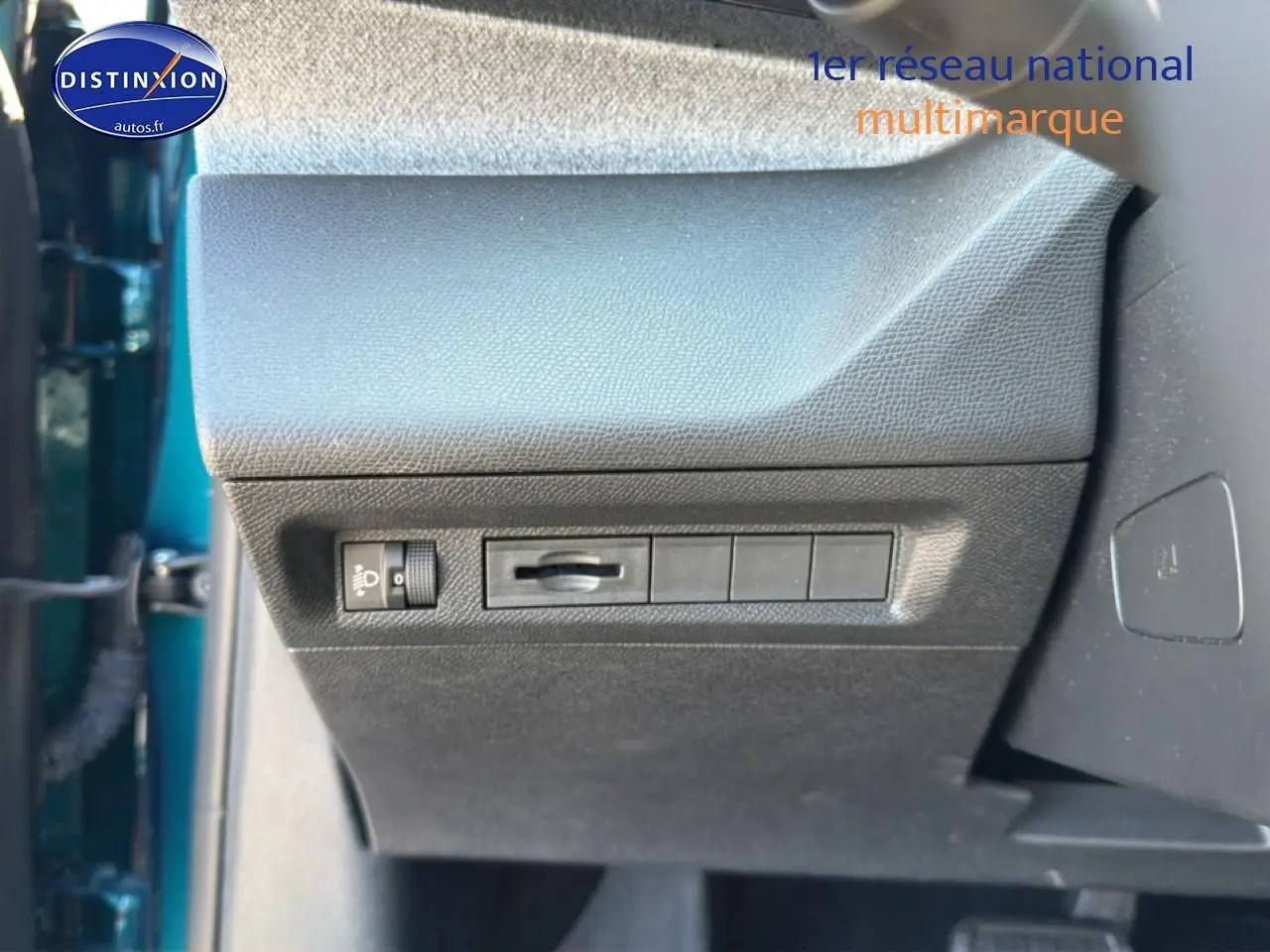 Vue rapprochée de la partie inférieure gauche du tableau de bord d’une Peugeot 408 bleu, avec commandes d’éclairage.
