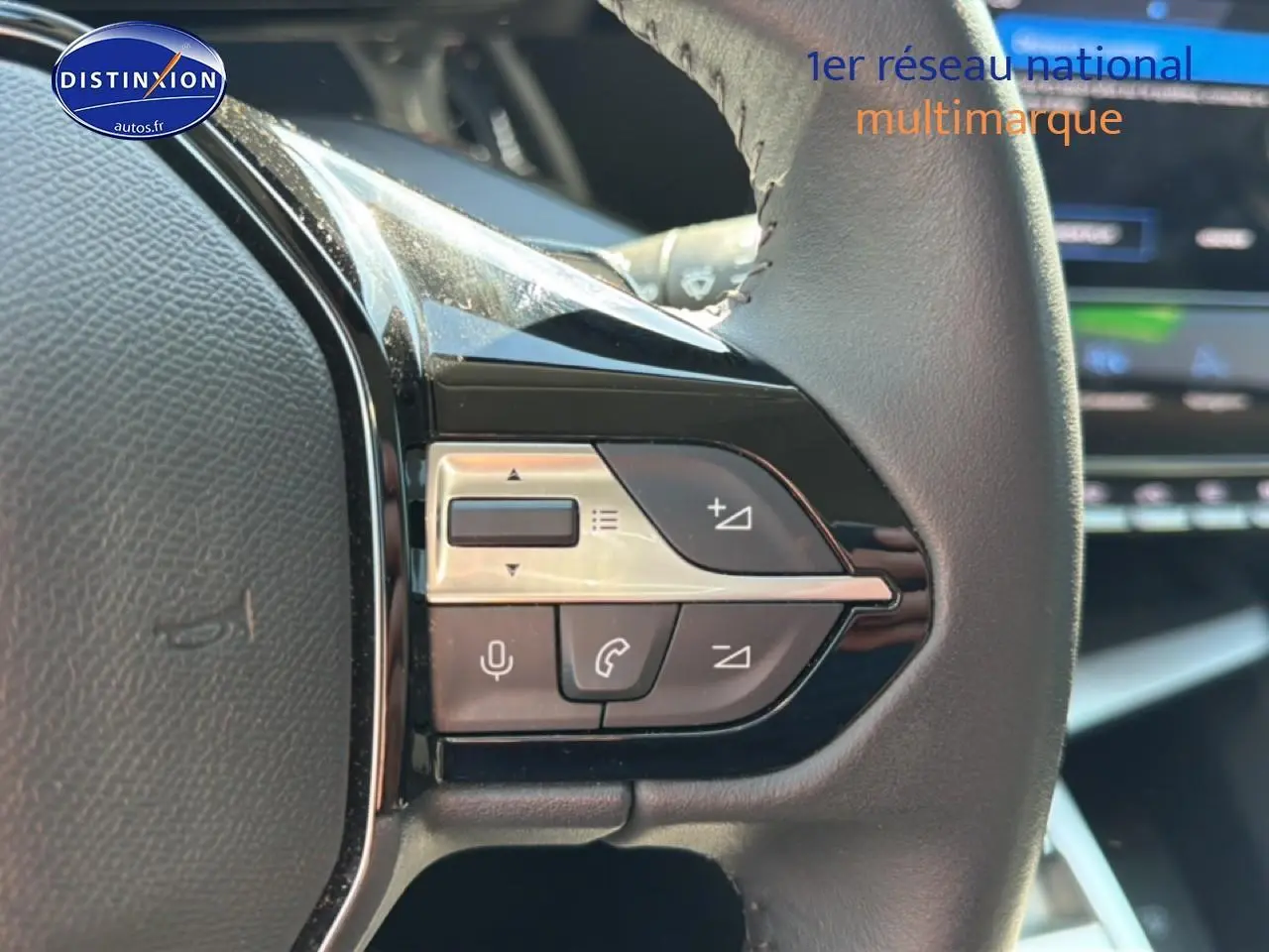Gros plan sur les commandes vocales et audio au volant cuir noir du Peugeot 408 Hybrid 145 allure bleu 2025.