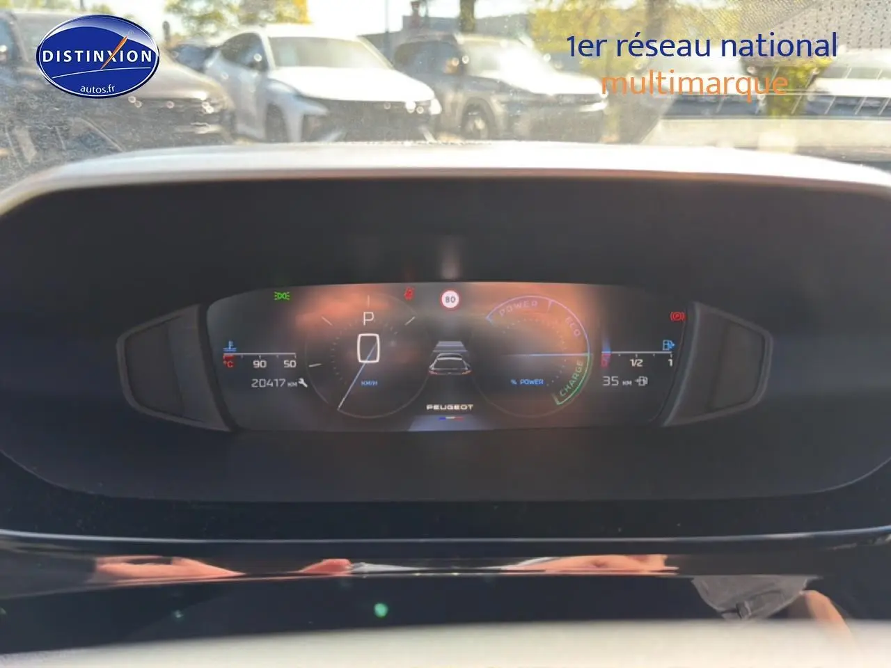 Vue rapprochée du tableau de bord numérique du Peugeot 408 Hybrid 145 allure e-dcs6, affichant la vitesse et l'autonomie.