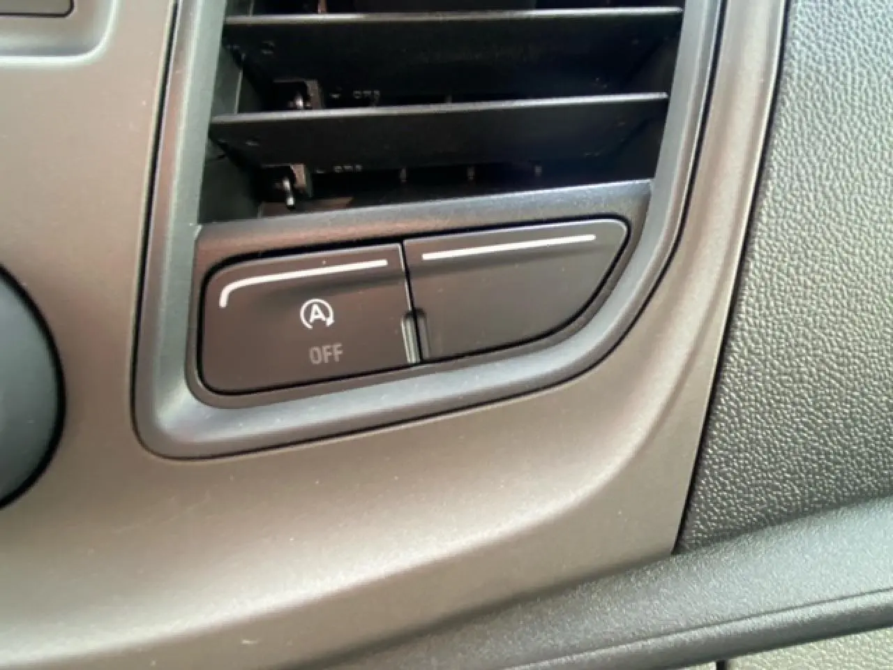 Gros plan sur le bouton d'arrêt du système start-stop dans l'habitacle du Ford Transit Fourgon blanc.