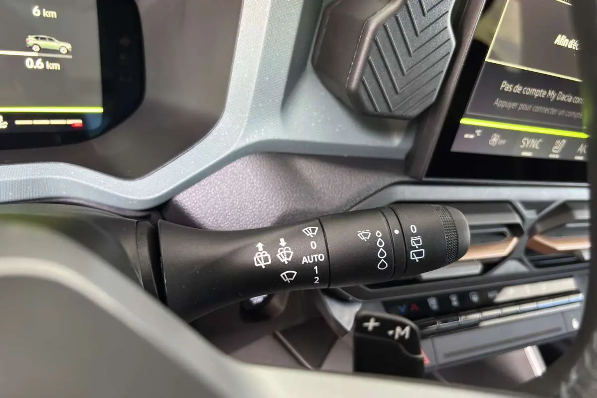 Gros plan sur la commande d’essuie-glace du tableau de bord du Dacia Bigster Hybrid-G 150 4x4 vert cèdre, intérieur moderne.