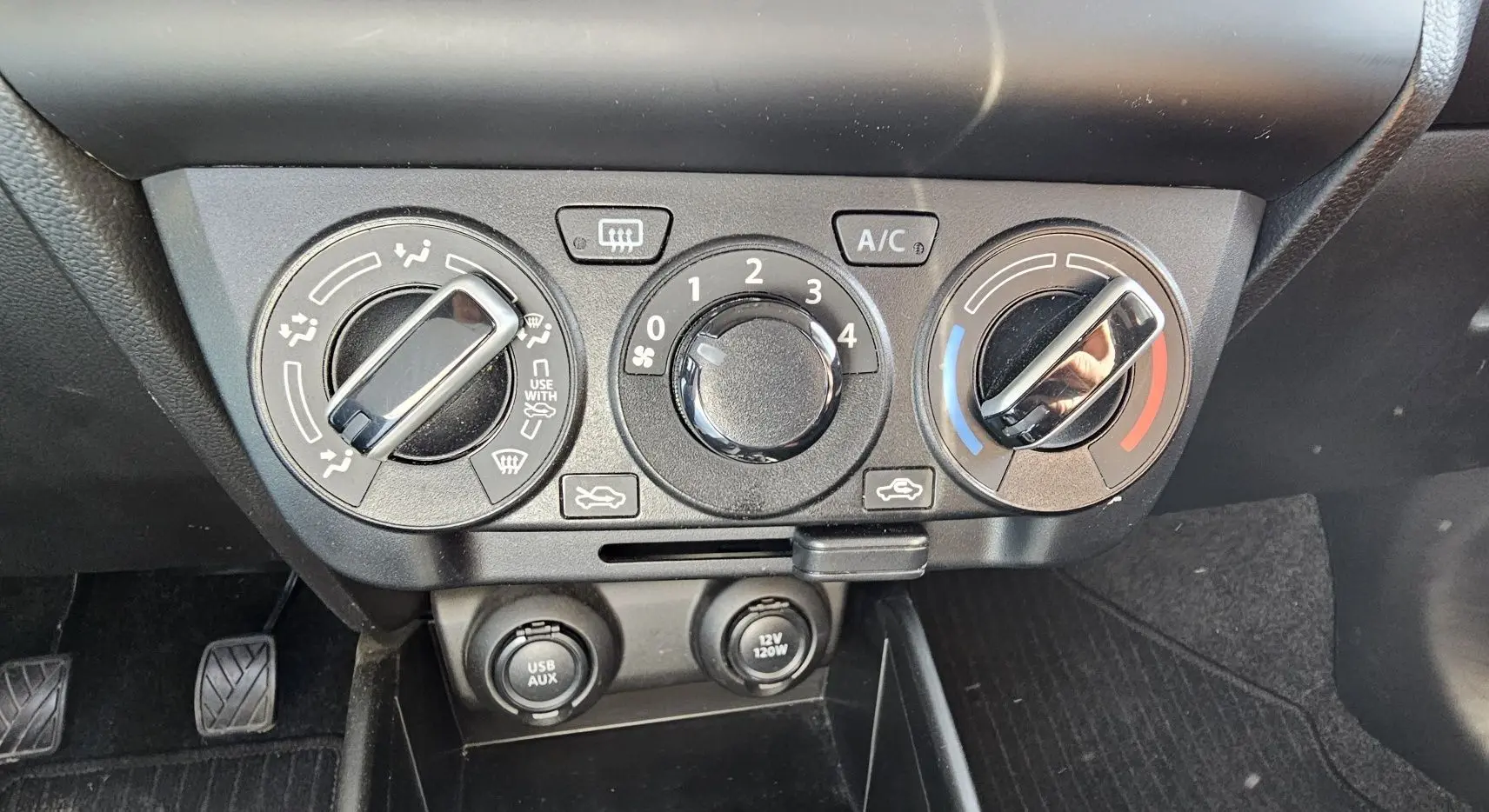 Panneau de commandes de climatisation manuel avec réglages de température, ventilation et prises USB/AUX sur Suzuki Swift 2023.