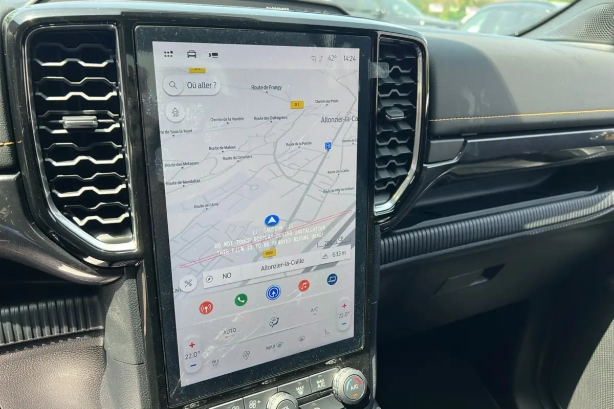 Vue rapprochée de la console centrale du Ford Ranger 2025 noir agate, avec écran tactile affichant la navigation et commandes climatisation.