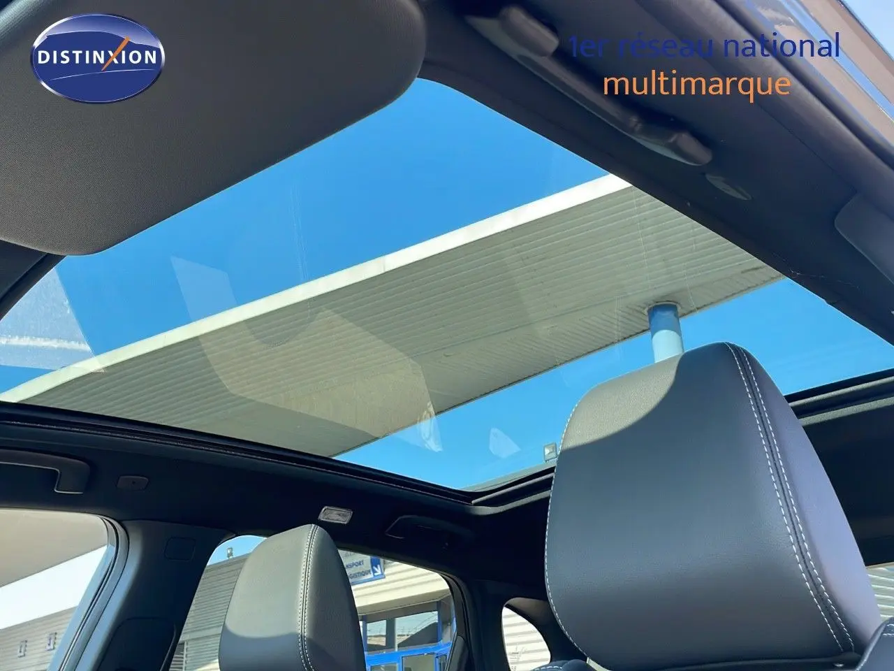 Toit panoramique ouvert vu de l'intérieur du Nissan Qashqai 2025 gris céramique avec sièges cuir noir.