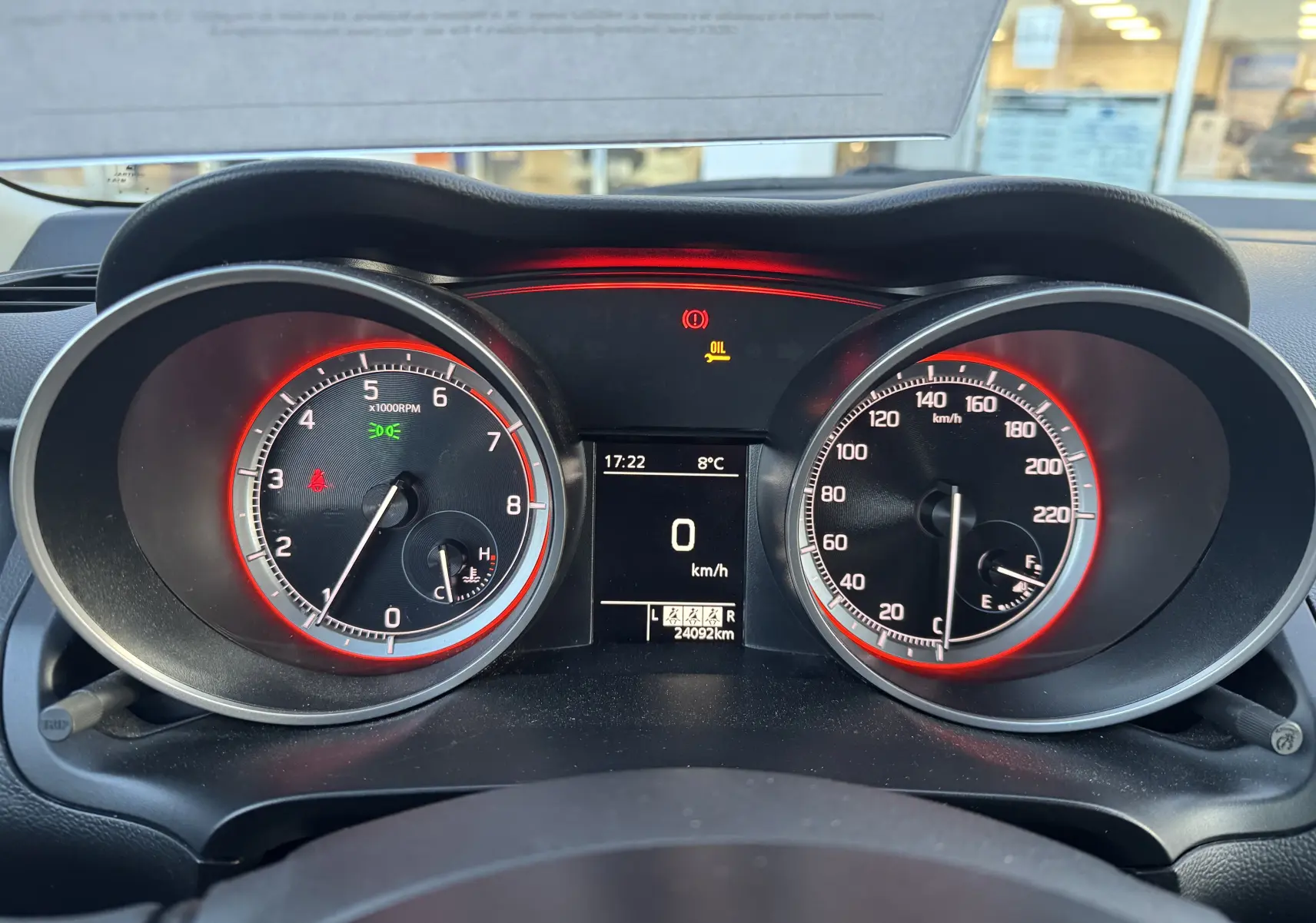 Vue rapprochée du tableau de bord de la Suzuki Swift 1.2 Dualjet Hybrid 2021 avec compte-tours et compteur de vitesse rétroéclairés en rouge.