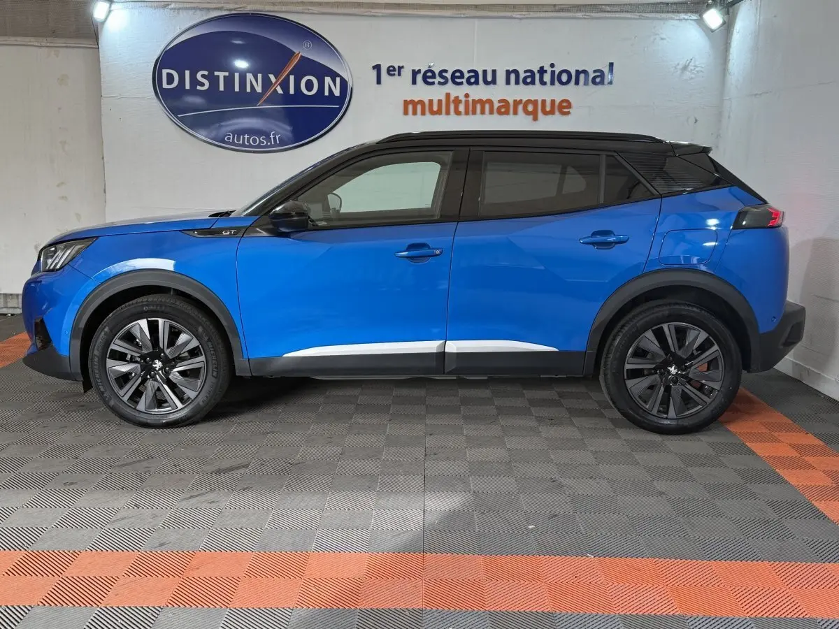 Peugeot 2008 Bleu GT Pack vue de profil côté gauche, toit noir contrastant et jantes alliage foncé.