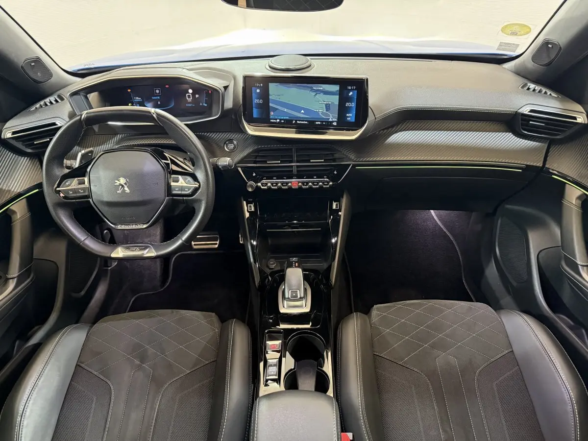 Vue intérieure avant du Peugeot 2008 GT Pack 2021, tableau de bord moderne avec écran tactile et volant cuir multifonctions.