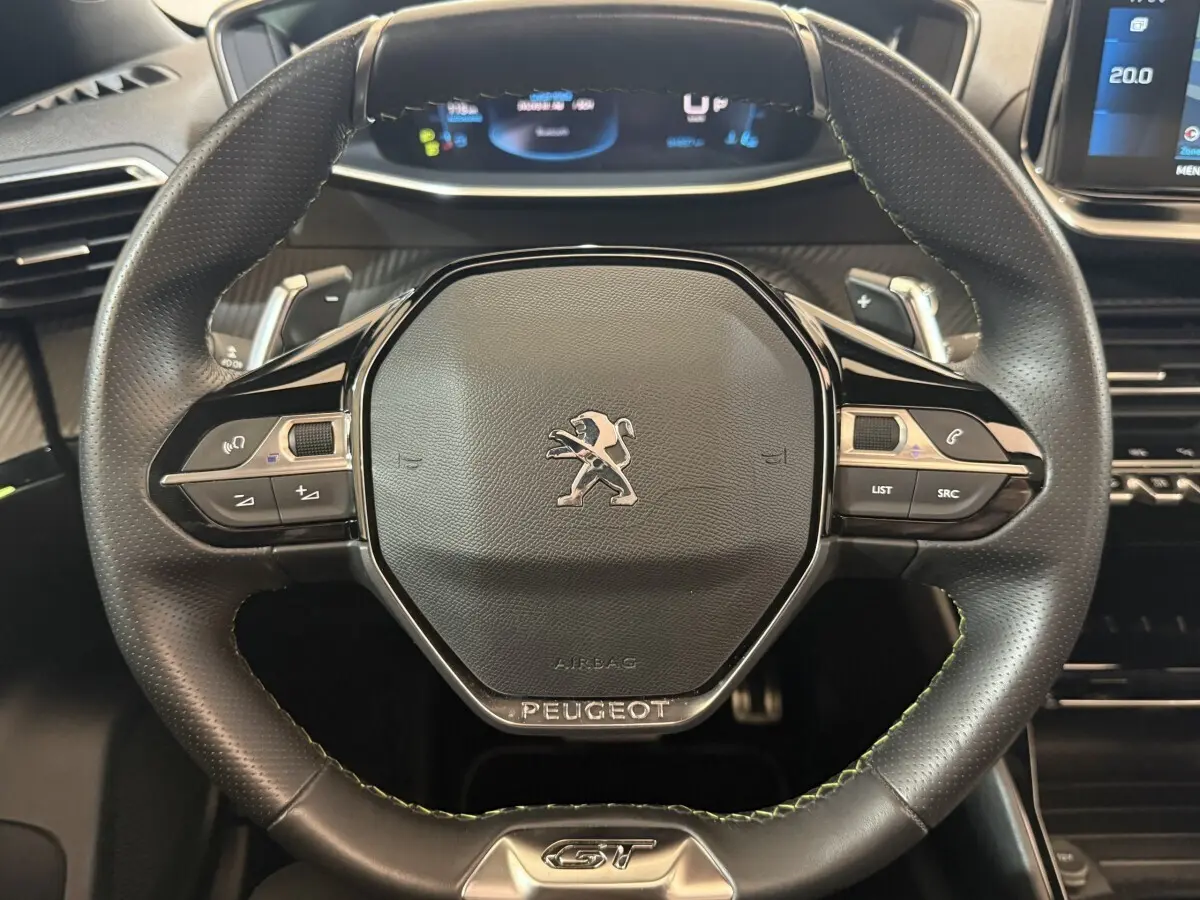 Gros plan sur le volant cuir noir du Peugeot 2008 GT PACK 2021 avec commandes intégrées et logo central.
