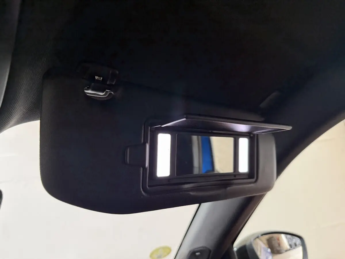 Miroir de courtoisie éclairé sur pare-soleil intérieur côté conducteur d’un Peugeot 2008 bleu, 2021.