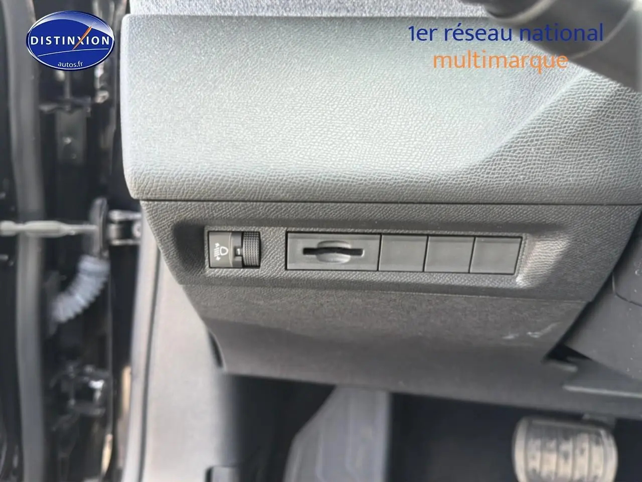 Détail du tableau de bord côté conducteur avec commandes d’éclairage et réglage, intérieur noir.