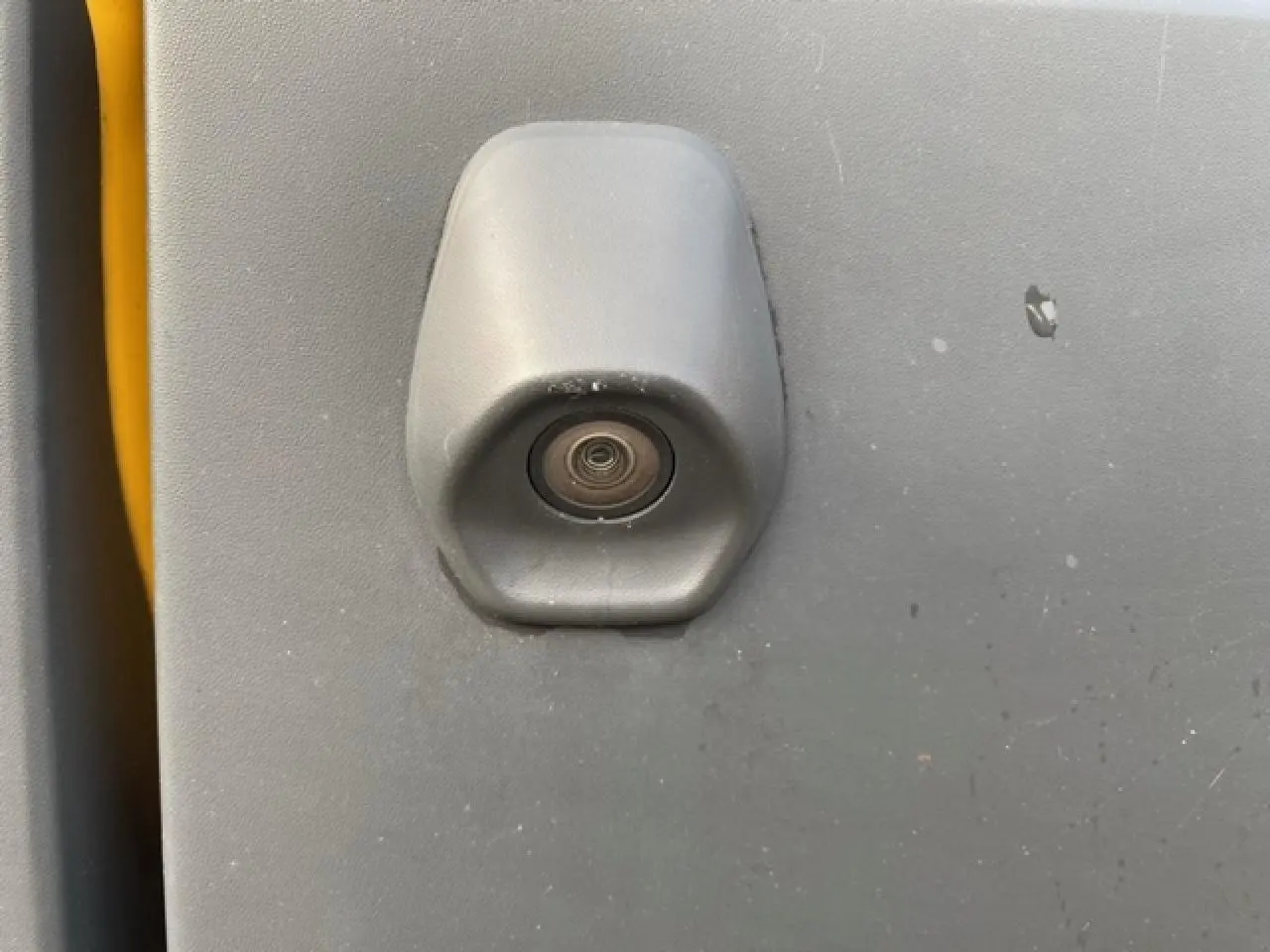 Gros plan sur la caméra de recul intégrée à la porte arrière grise du Ford Transit Fourgon orange.
