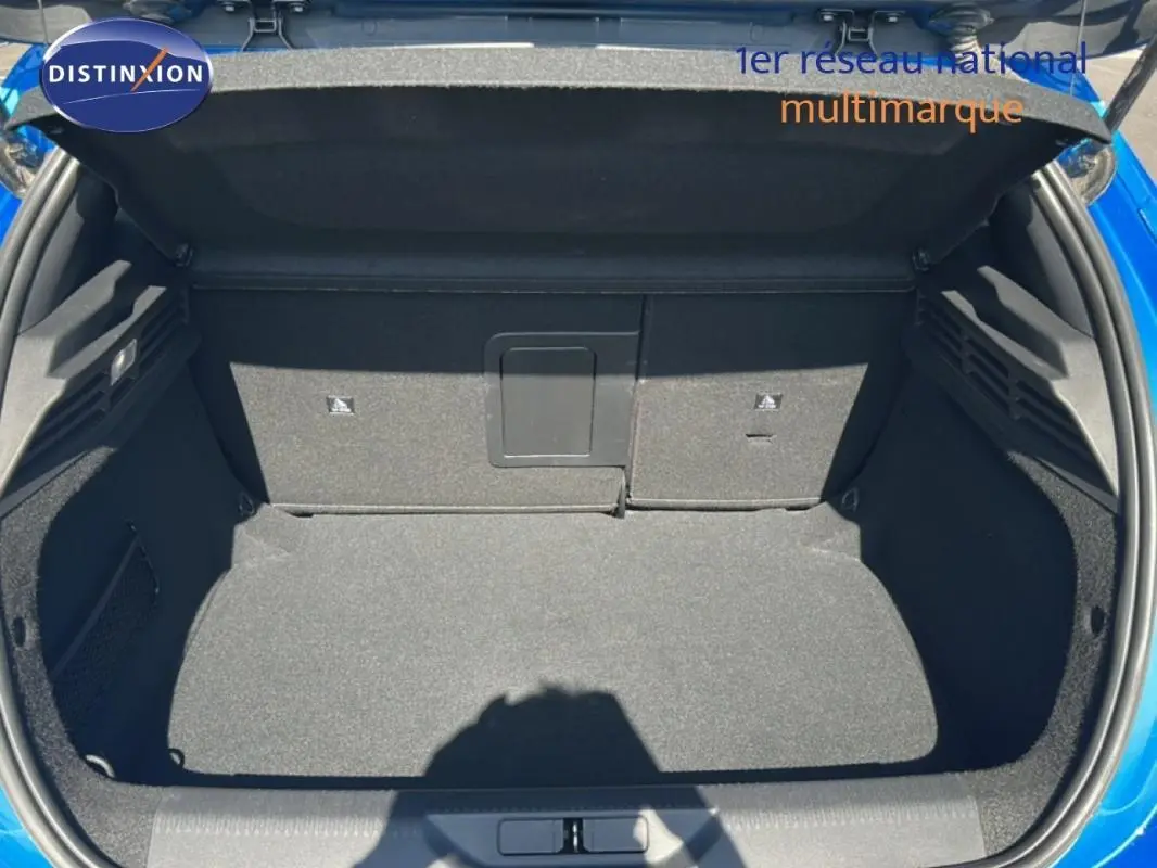 Coffre ouvert vu de face d'une Peugeot 308 bleu clair 2021, montrant un espace de chargement propre et spacieux.