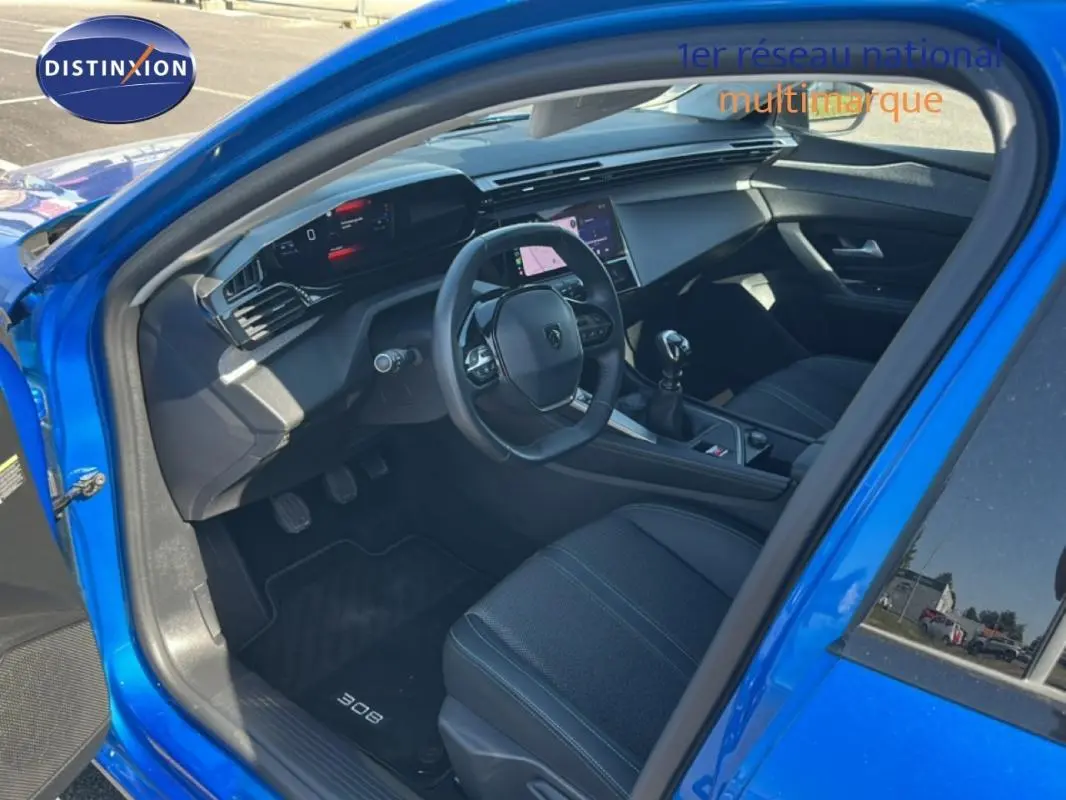 Vue intérieure côté conducteur de la Peugeot 308 bleu clair 2021, avec tableau de bord numérique et écran tactile central.