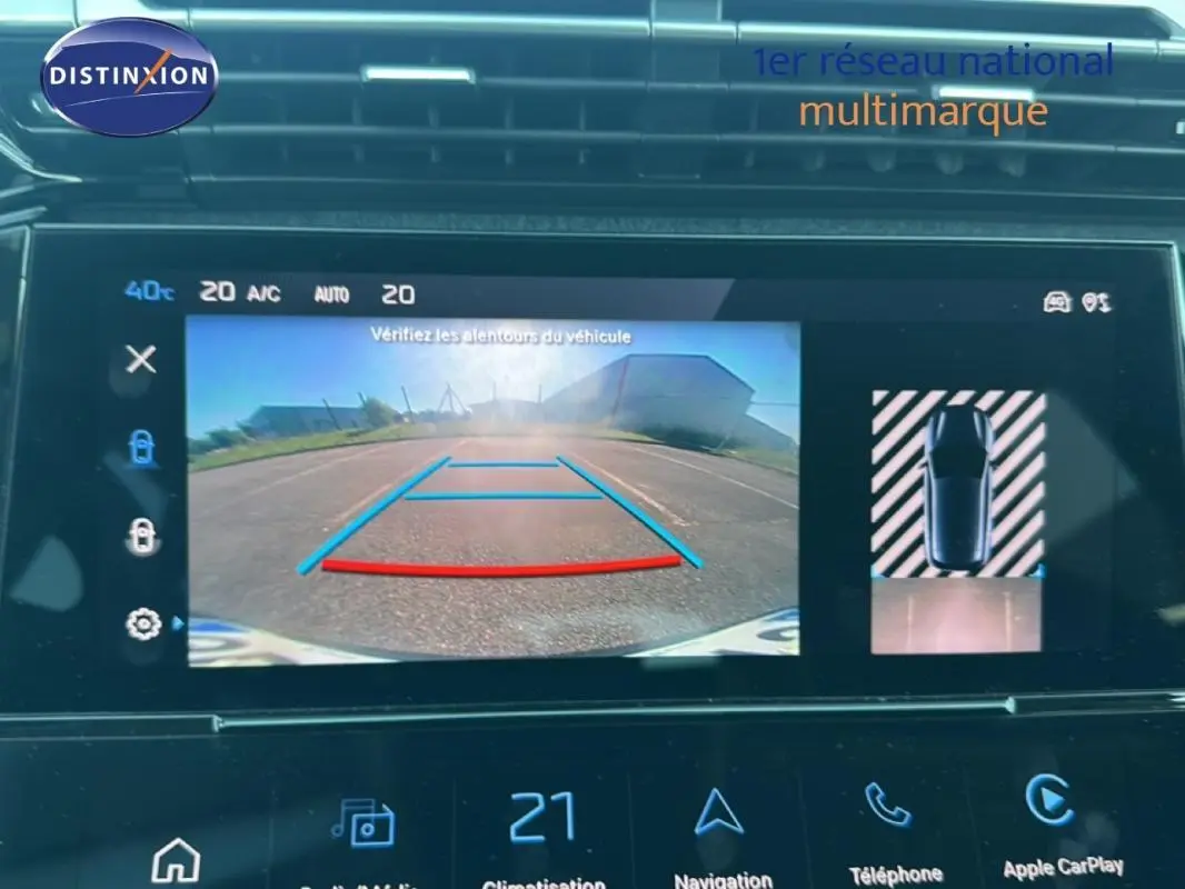 Écran tactile intérieur de la Peugeot 308 bleu clair 2021 montrant la caméra de recul et l'aide au stationnement.