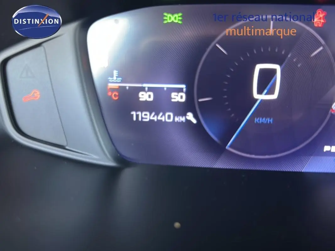 Tableau de bord numérique de Peugeot 308 bleu clair, affichant 119440 km et vitesse à 0 km/h, vue de face rapprochée.