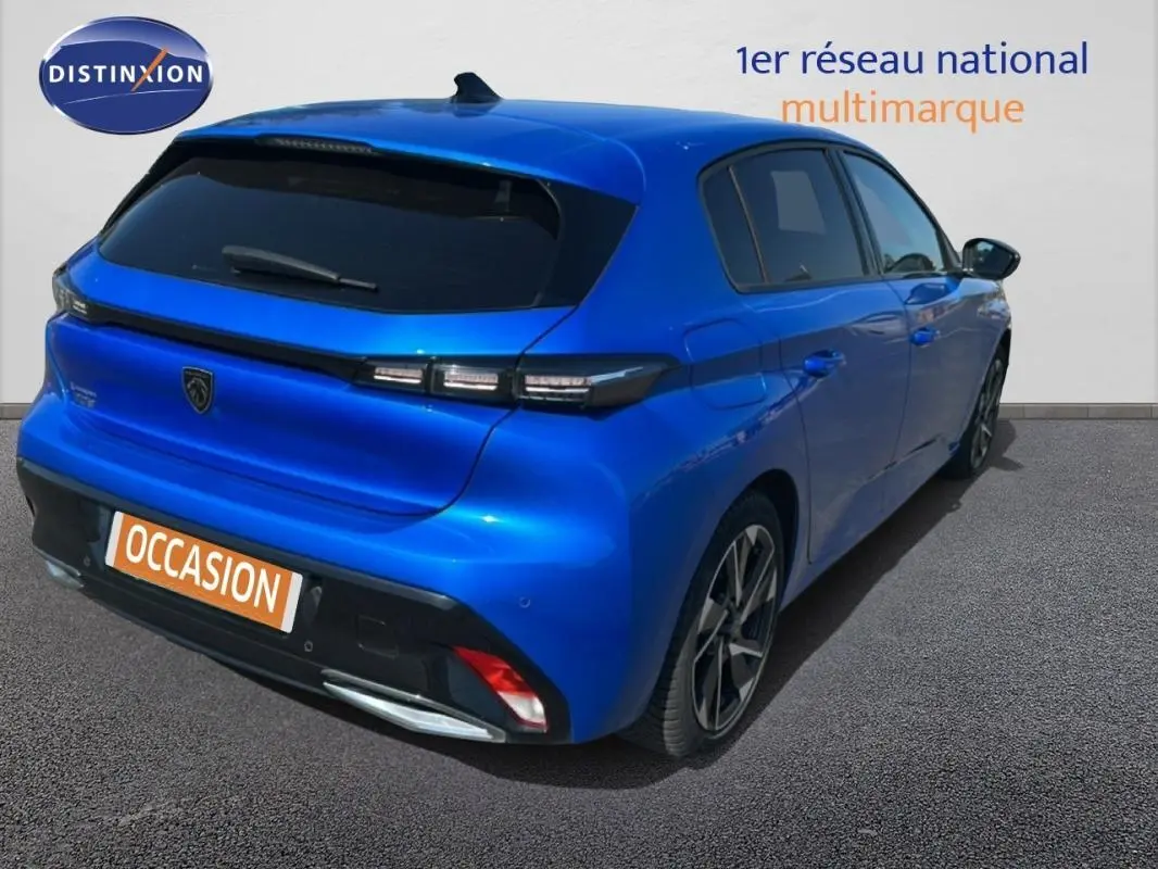 Vue 3/4 arrière droite d'une Peugeot 308 bleu clair avec jantes alliage et feux arrière LED distinctifs.