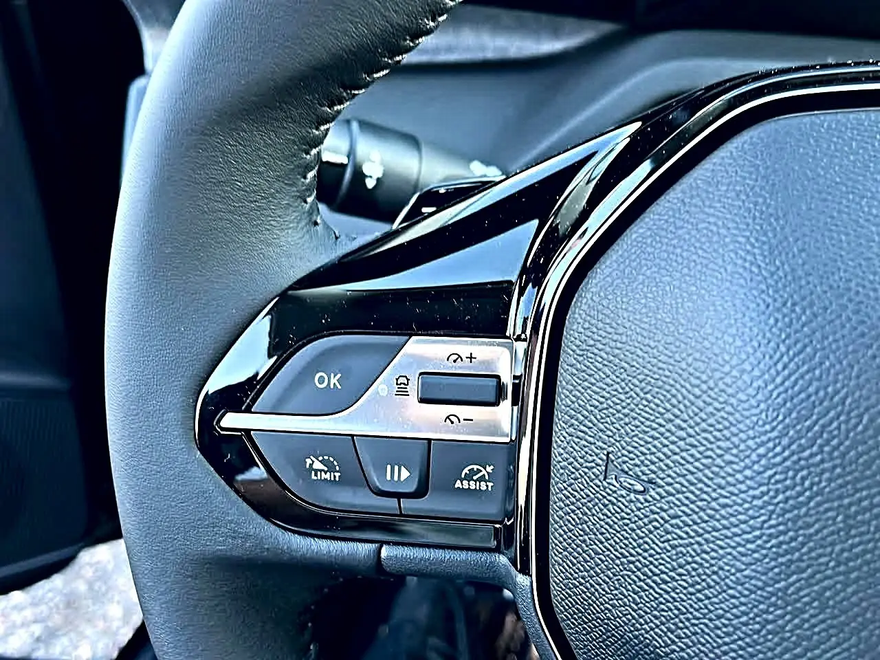 Gros plan sur le volant noir multifonction de la Peugeot 308 SW 2025 avec commandes de régulateur de vitesse.