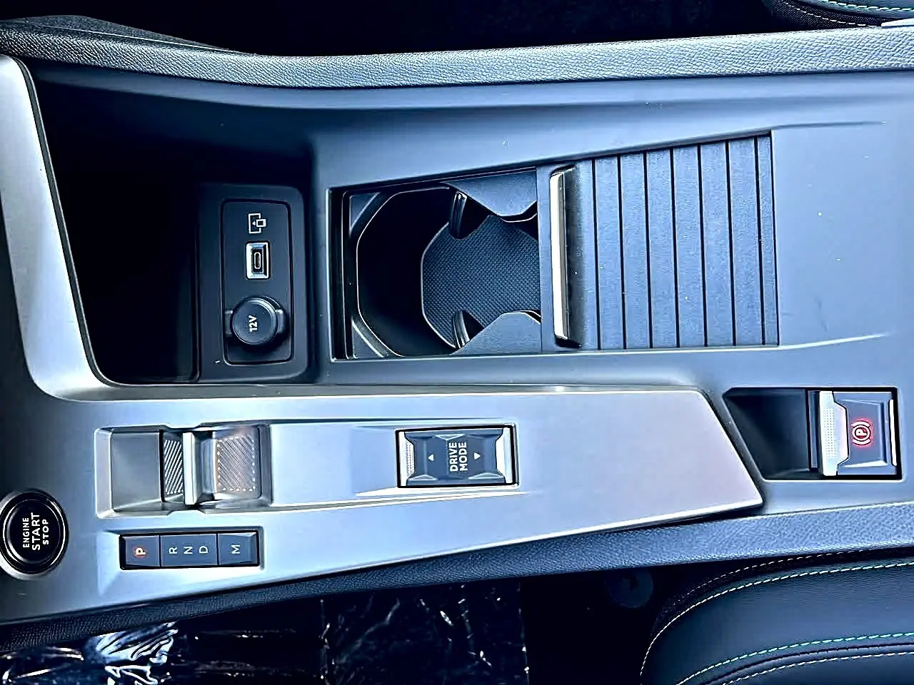 Vue plongeante sur la console centrale grise du Peugeot 308 SW noire, montrant levier de vitesse et rangements.