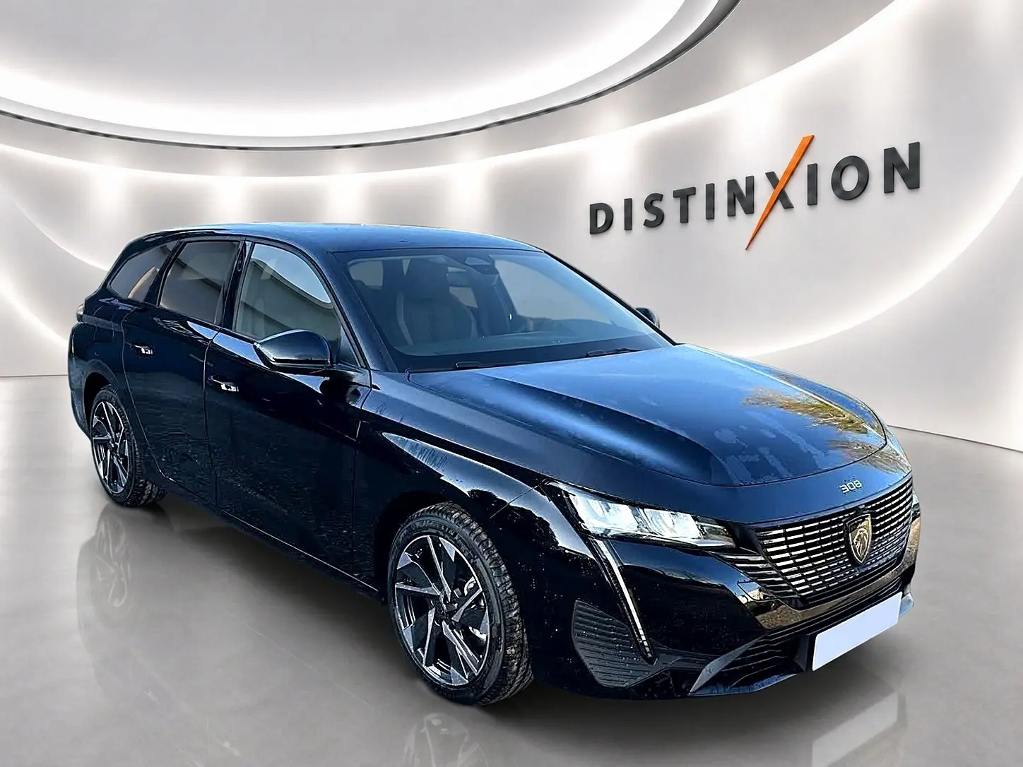 Peugeot 308 SW noire vue en 3/4 avant droit, avec calandre distinctive et jantes alliage modernes.