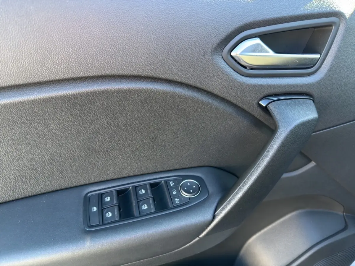 Détail de la porte côté conducteur du Renault Captur gris foncé, avec commandes électriques des vitres et poignée intégrée.
