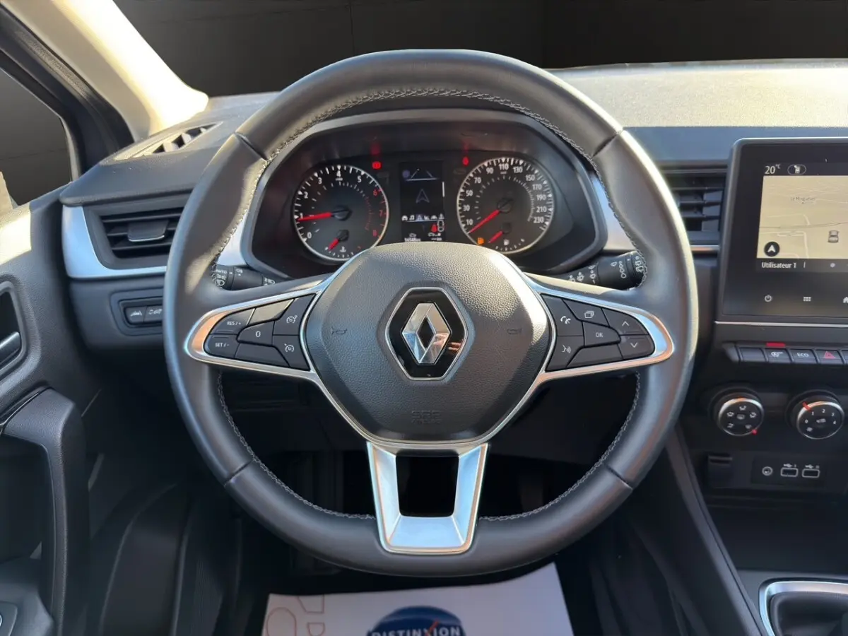 Vue centrée sur le volant cuir du Renault Captur 2024 avec tableau de bord et écran tactile de navigation visible.