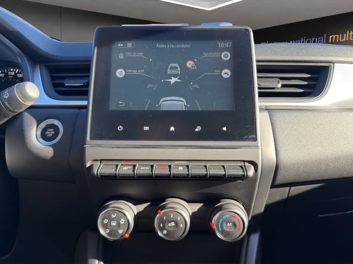 Vue rapprochée du tableau de bord du Renault Captur gris foncé 2024, avec écran tactile central affichant les aides à la conduite.