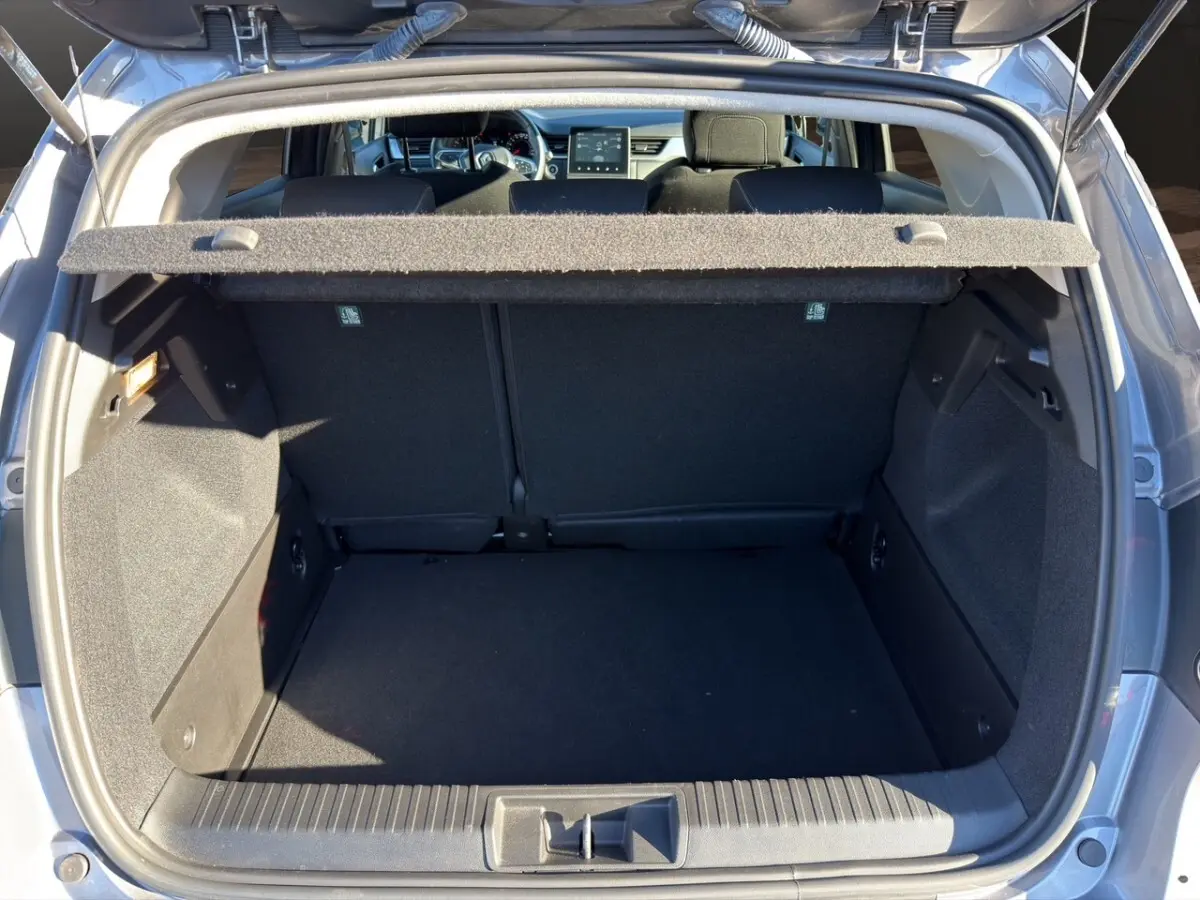 Coffre ouvert vu de l'arrière du Renault Captur gris foncé 2024, montrant l'espace de chargement vide et la tablette cache-bagages.