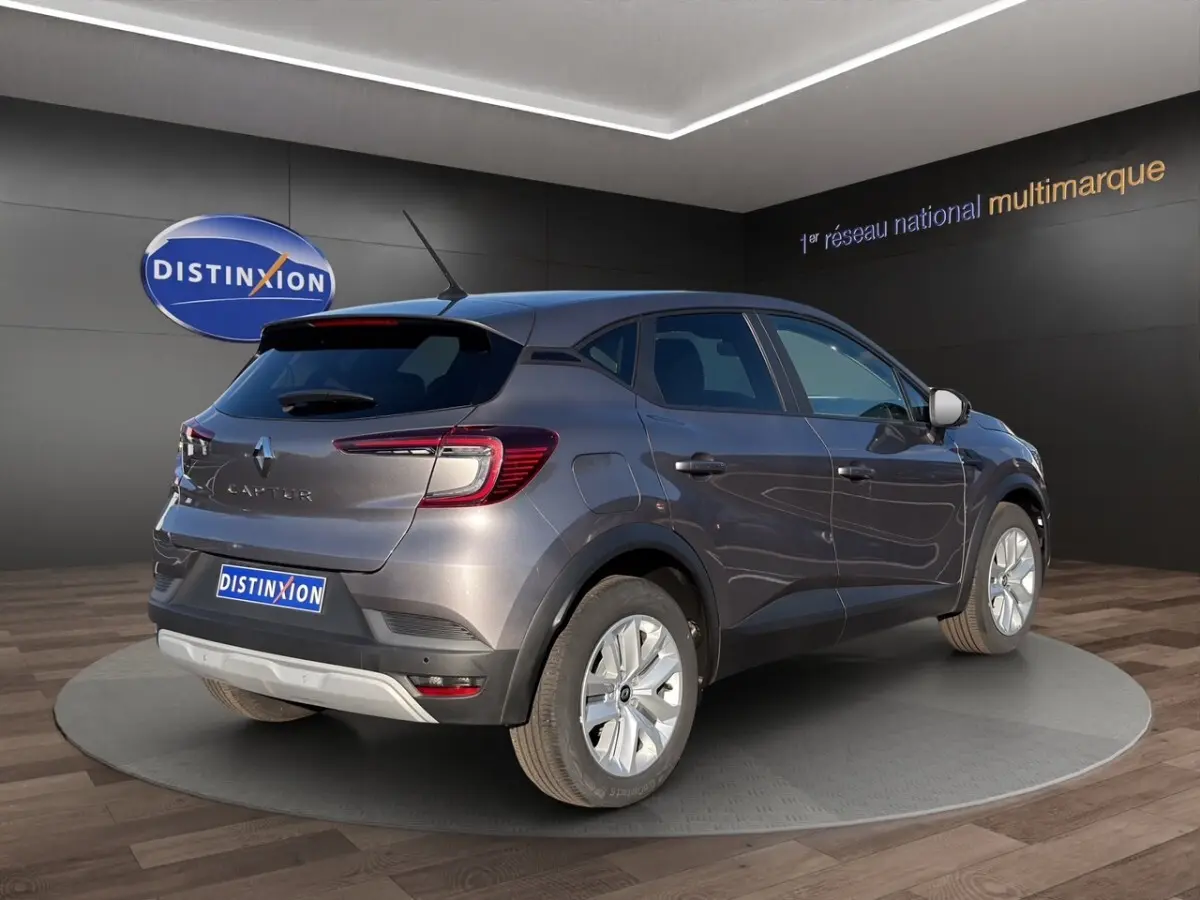 Vue 3/4 arrière droite du Renault Captur gris foncé 2024 avec feux LED et jantes alliage visibles en showroom.