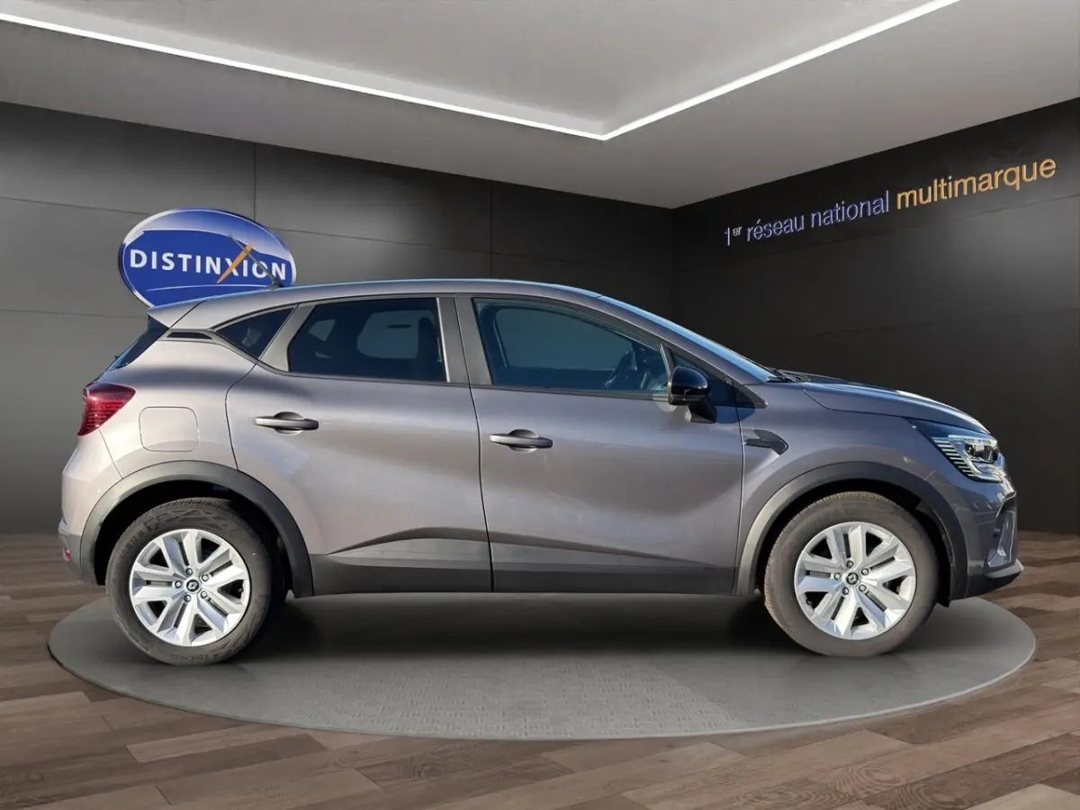 Profil côté gauche du Renault Captur gris foncé 2024 sur plateau tournant en showroom avec jantes alliage.