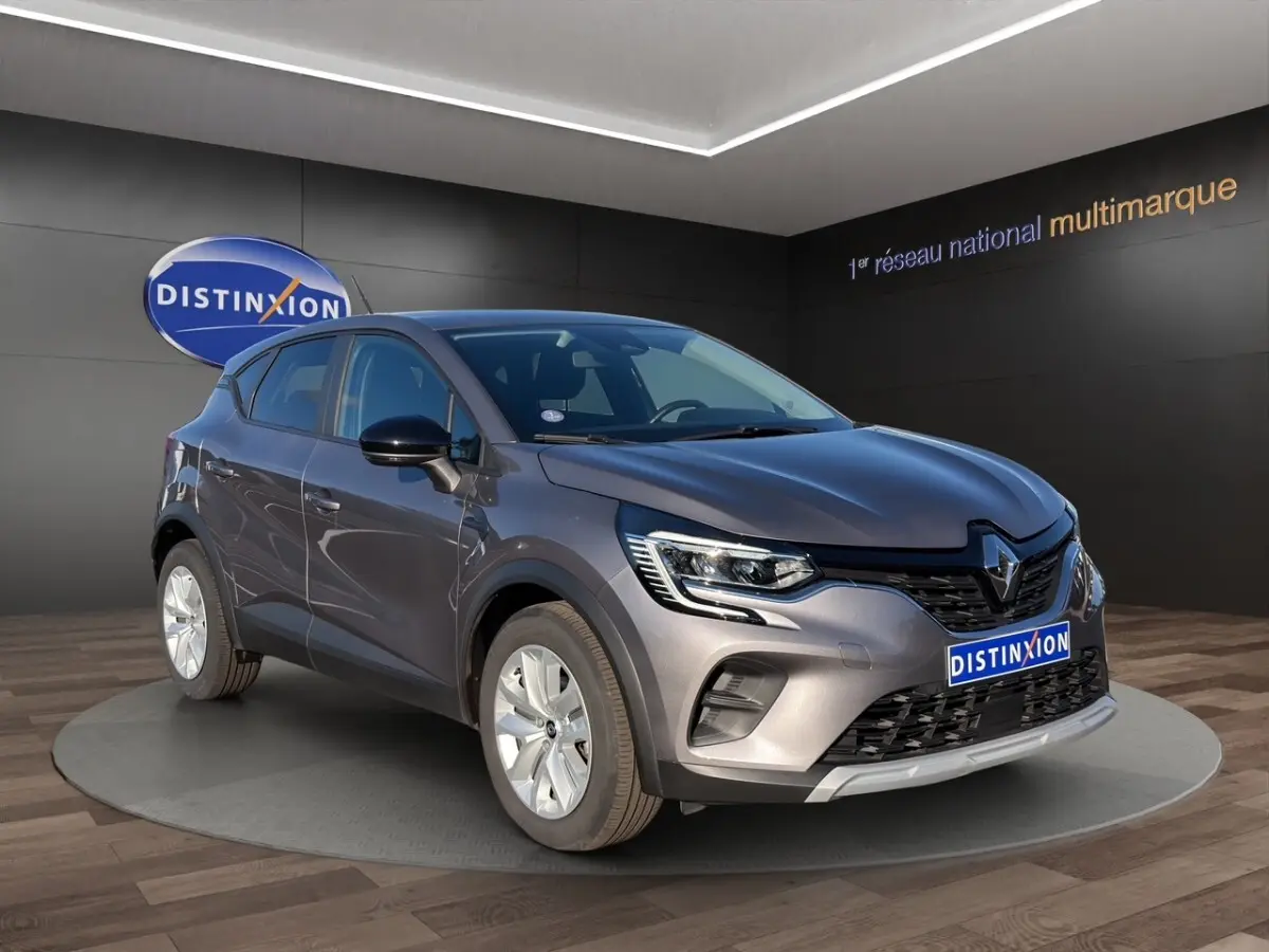 Renault Captur gris foncé en vue 3/4 avant droit, avec calandre noire et phares LED distinctifs.